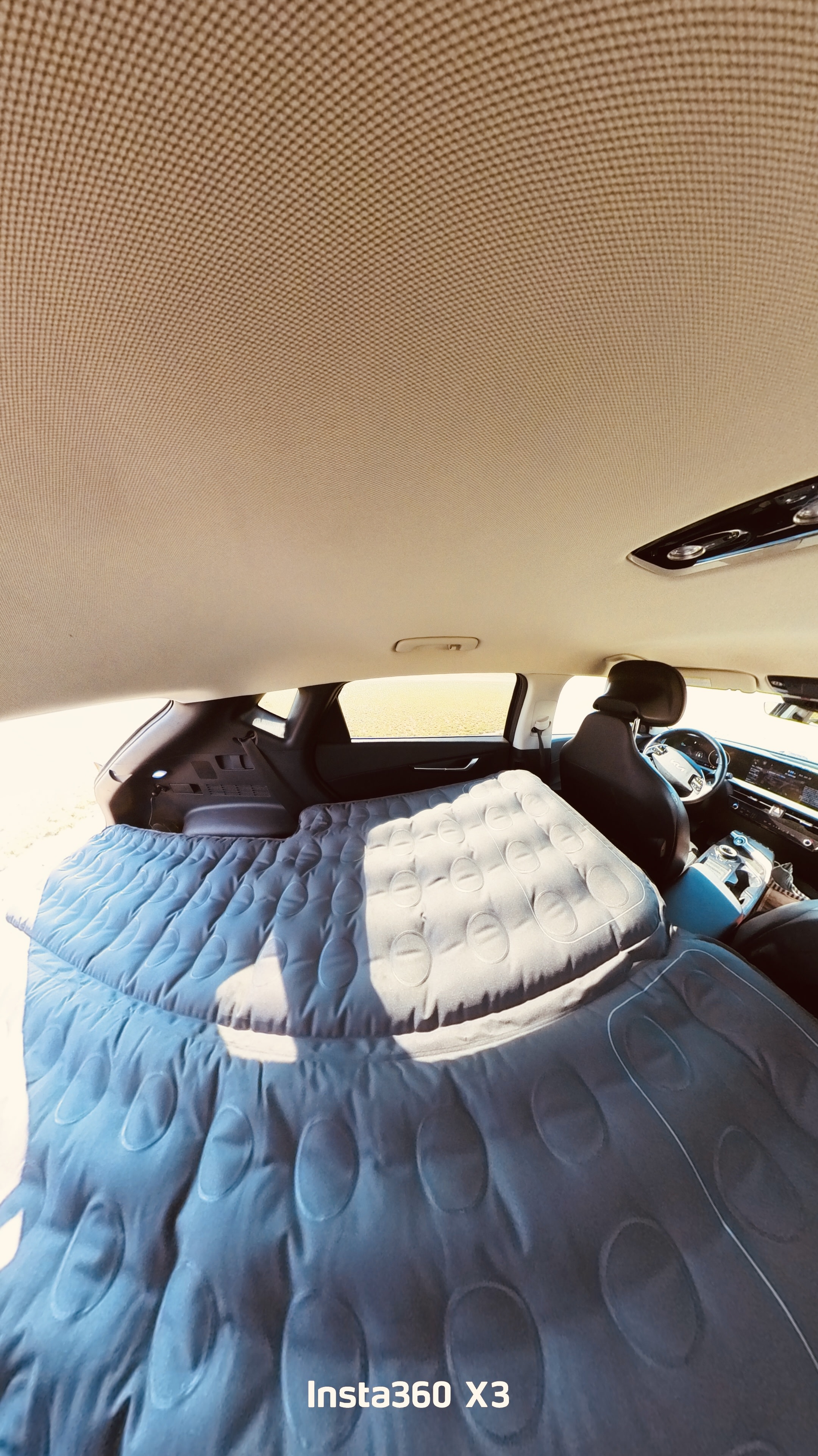 Car interior transformed into a sleeping space with an inflatable air mattress, ideal for a comfortable RV rental-like road trip. #carcamping. Kia EV6 Wind All Wheel Drive 2022