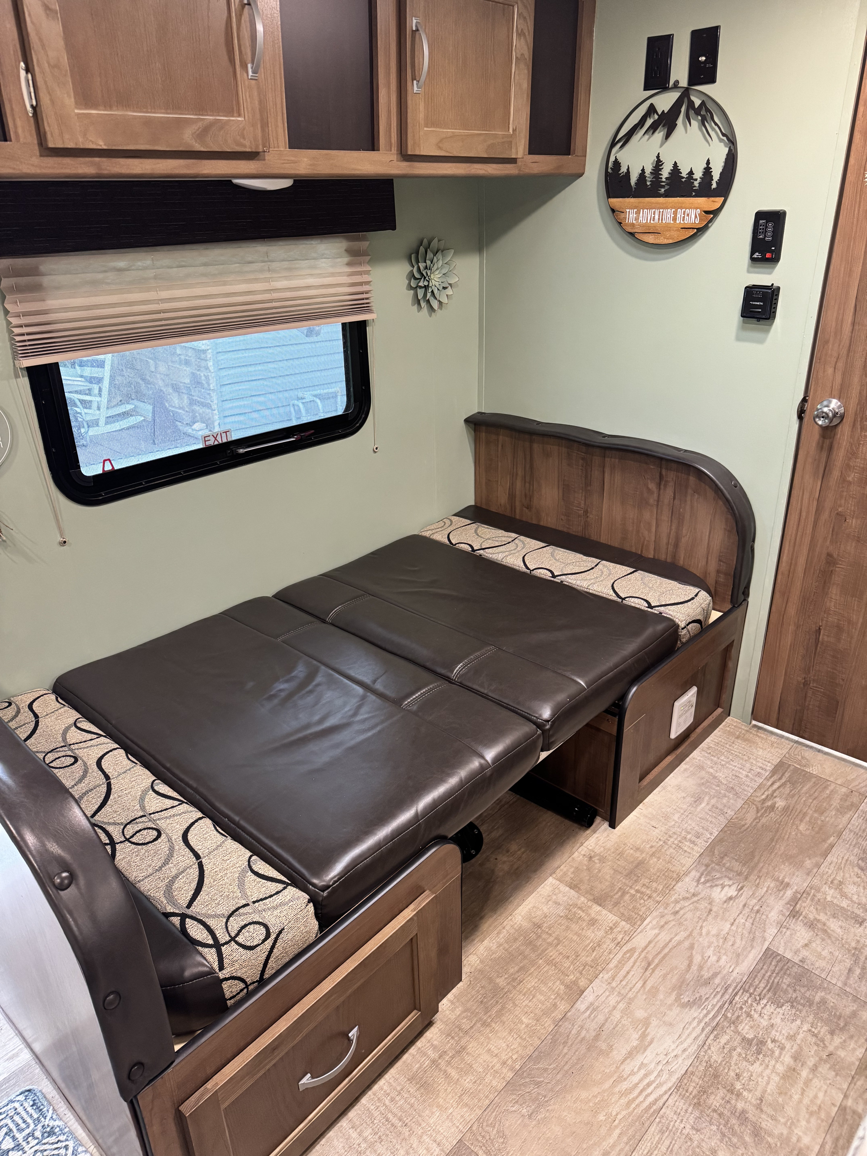 Experience comfort in this RV rental with a convertible sofa bed, featuring modern wood accents and decor.. Gulf Stream Ameri-Lite Super Lite 2019