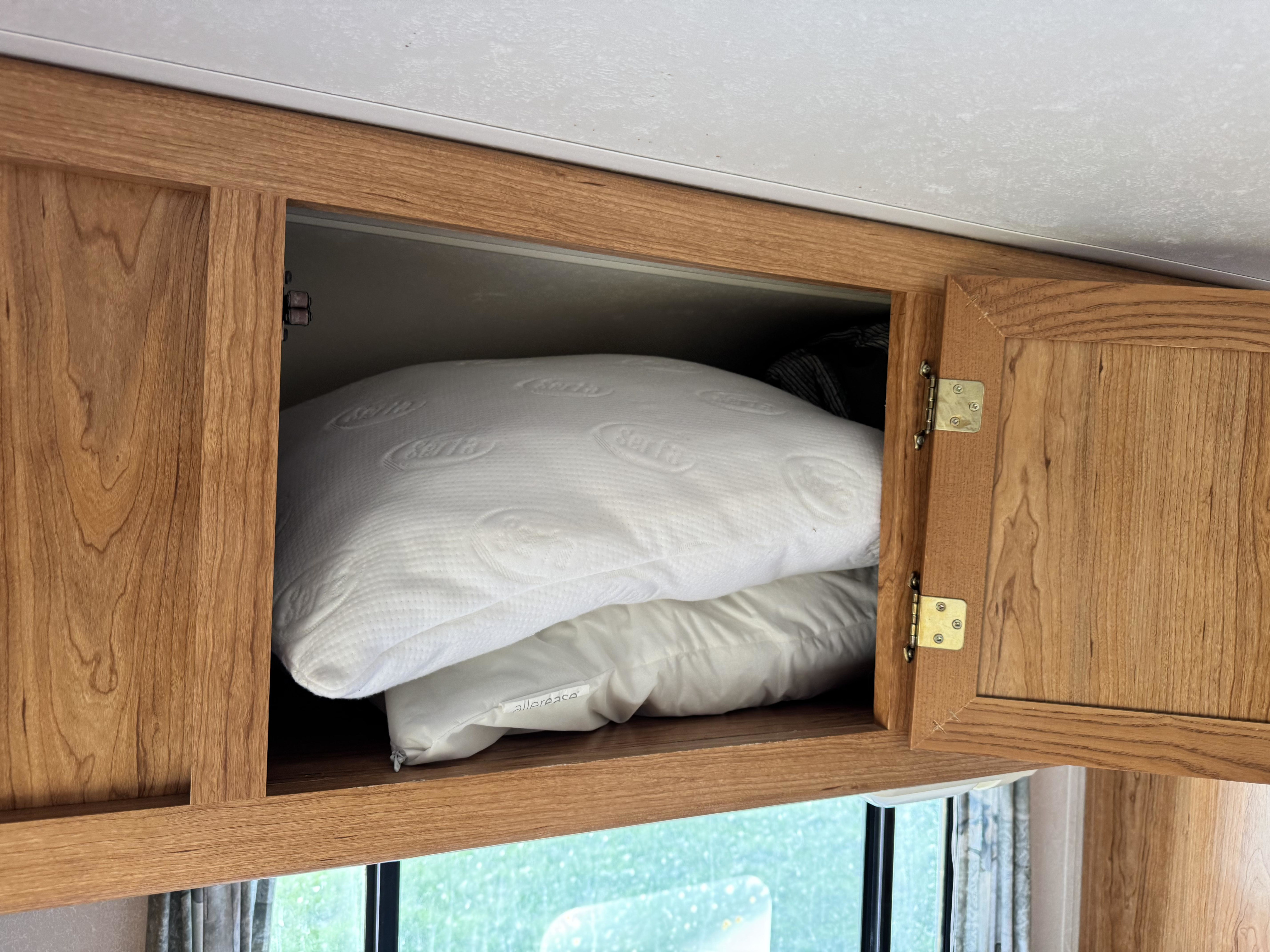 Open RV rental cabinet storing clean Serta and allerrease pillows.. Coachmen Leprechaun 2001