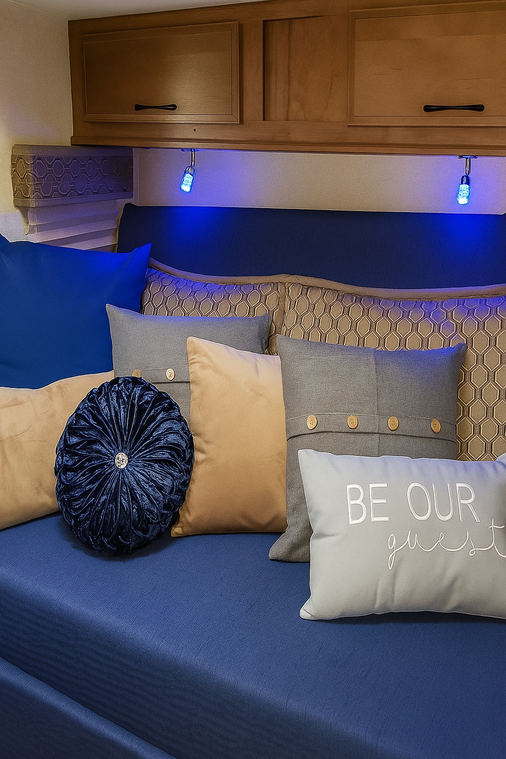 Comfortable RV rental daybed features blue bedding, various decorative pillows, and subtle ambient lighting.. Gulf Stream Conquest 2019