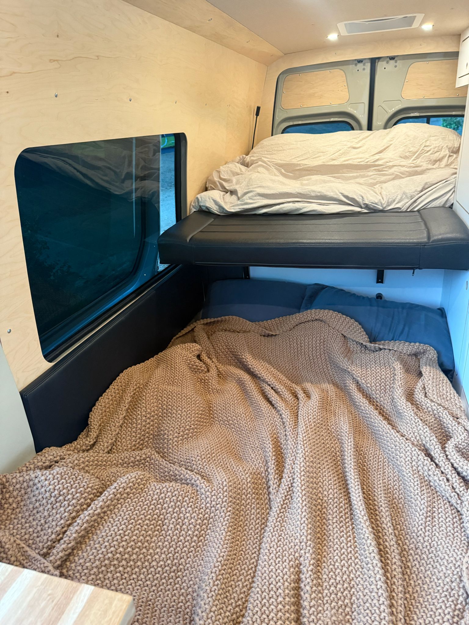 Cozy RV rental interior: bunk beds, wooden walls, large window. Ideal for a camper van adventure.. Mercedes-Benz Allterra AWD 2025