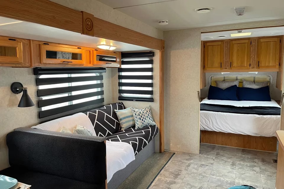 Spacious RV rental interior featuring a modern living area with daybed and cozy rear bedroom. Perfect for your next adventure.. Jayco Eagle 2002
