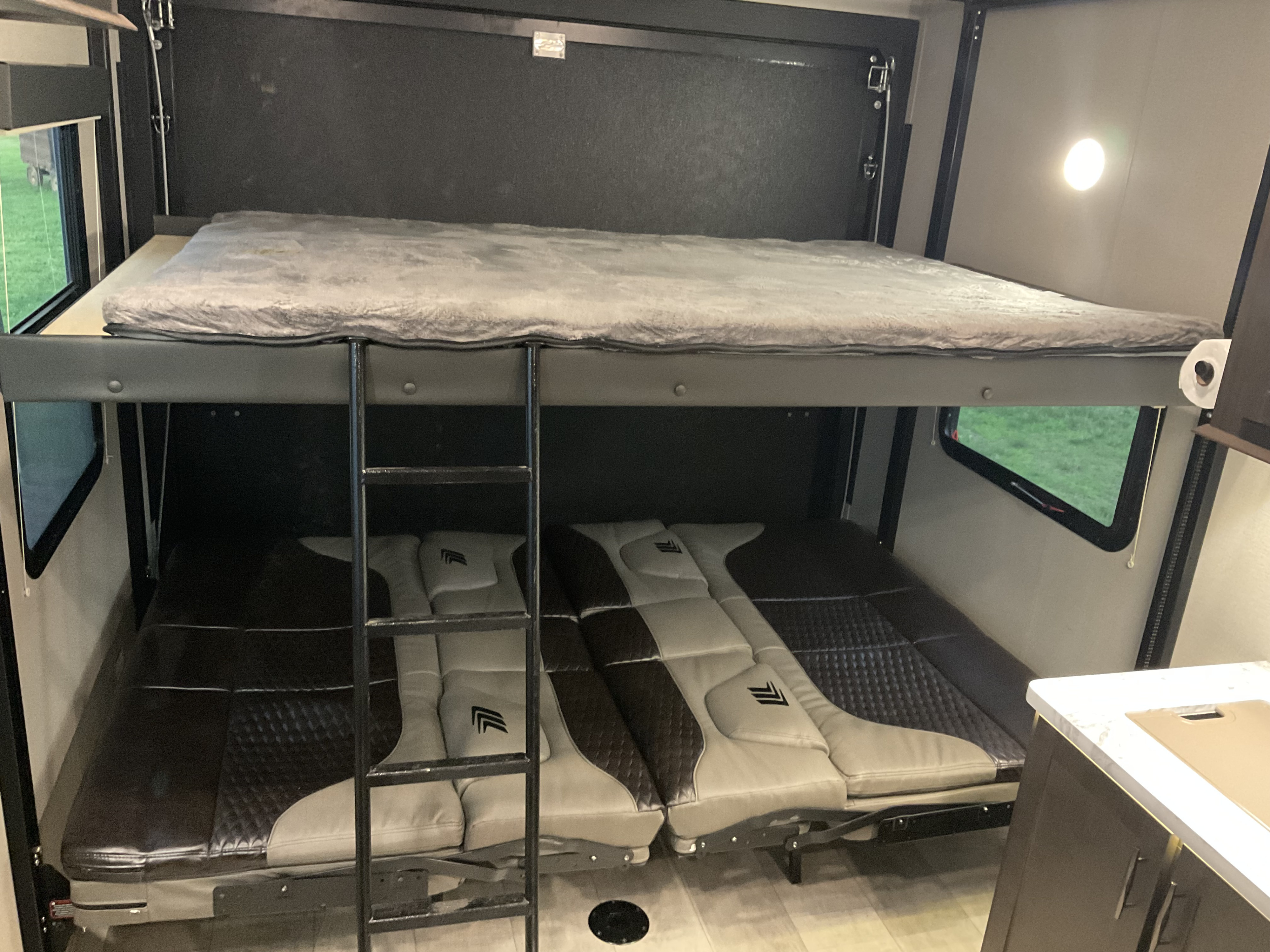 This RV rental's interior features a sturdy bunk bed setup with a soft top mattress and versatile lower cushions.. Grand Design Momentum 2021