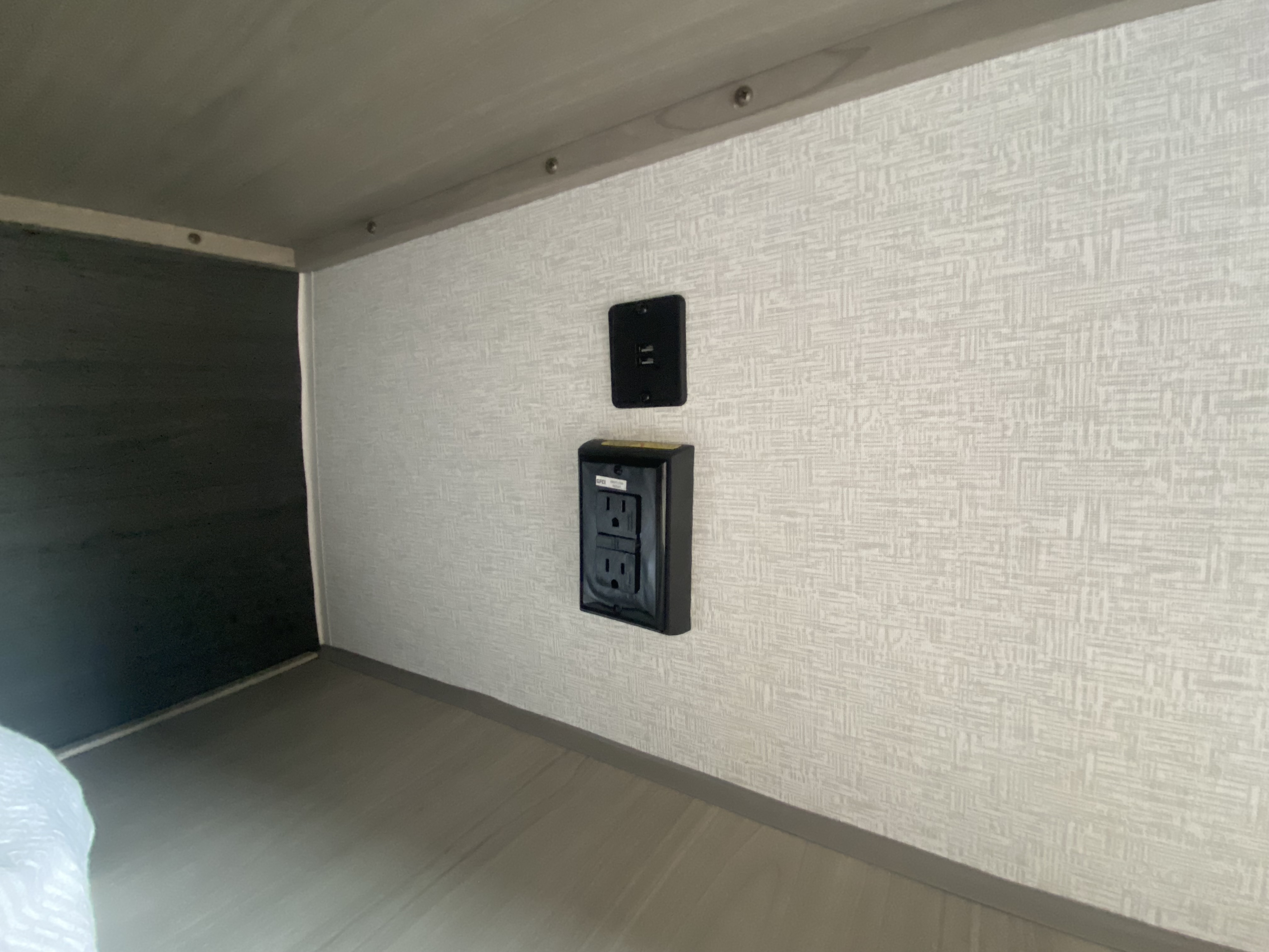 RV rental interior showing wall outlets (GFI & USB) in a compact bunk area, essential for charging devices.. Keystone RV Springdale 2024