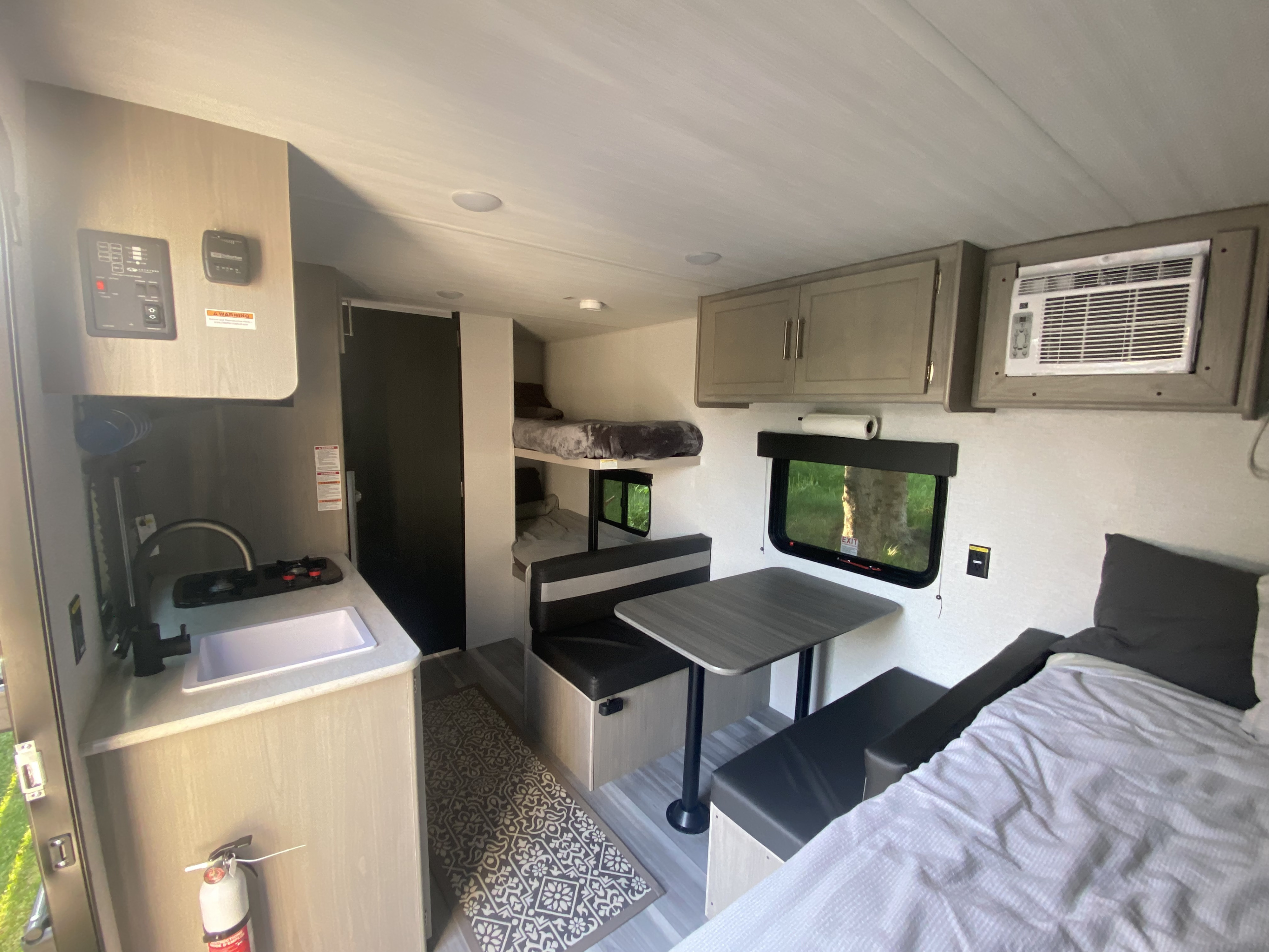 RV rental interior: Kitchenette, dining area, bunk beds, and main bed. All essentials for a comfortable trip.. Keystone RV Springdale 2024