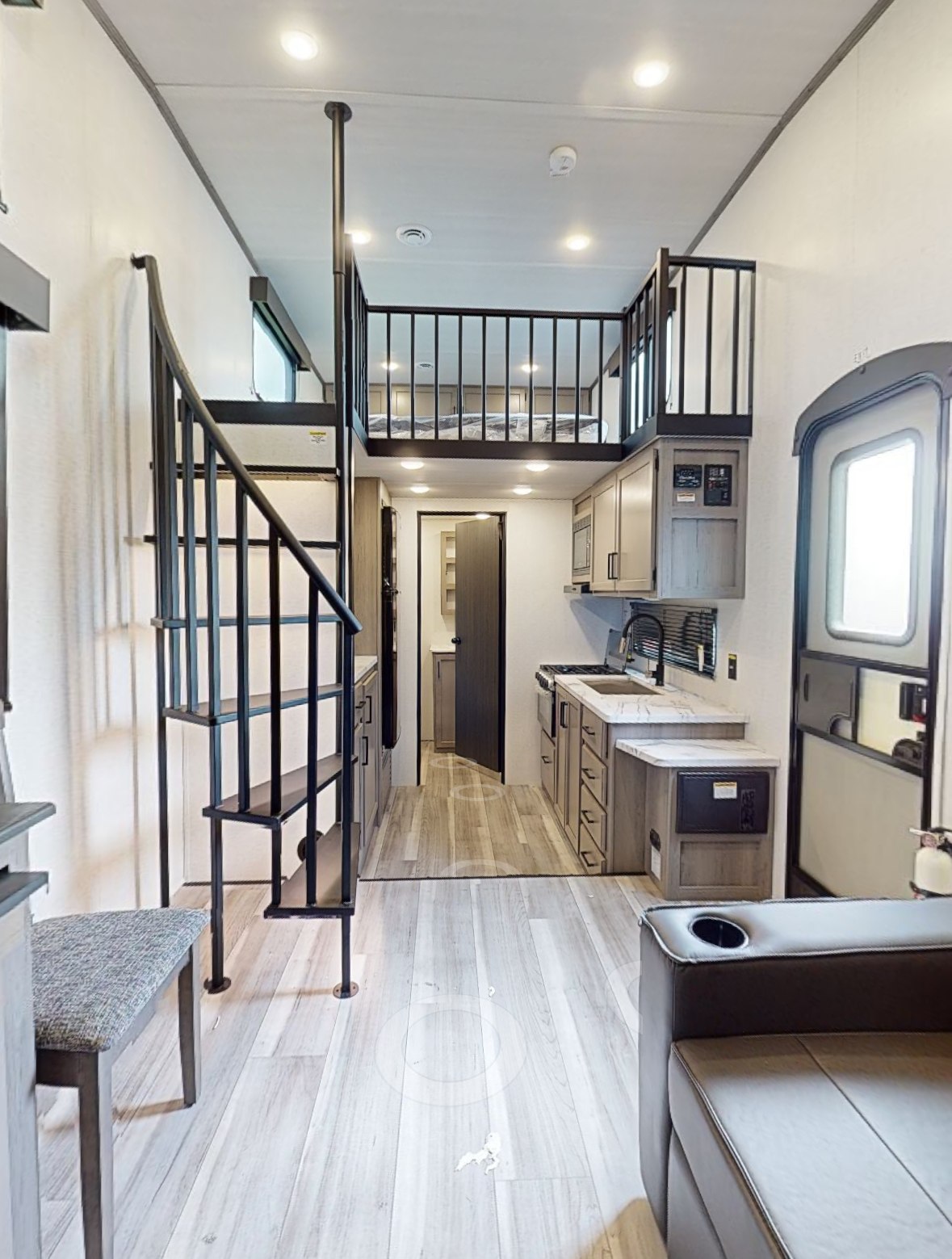 RV rental interior: spiral stairs lead to a loft bed, a compact kitchen, and a comfortable living space.. Keystone RV Hideout 2024
