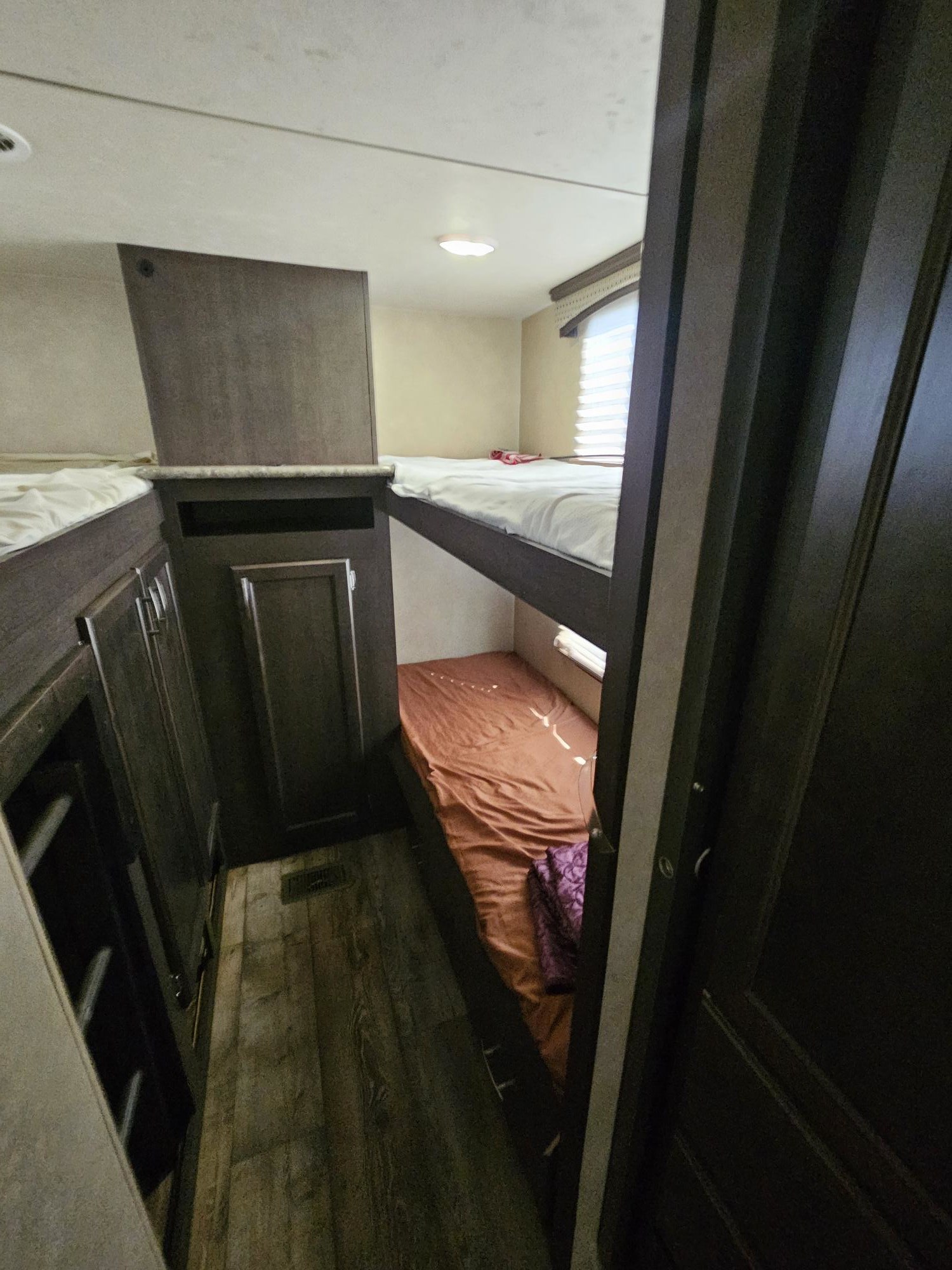 Inside an RV rental: a cozy bunk room with two beds and built-in storage. Ideal for family camping or travel.. Forest River Sierra 2017