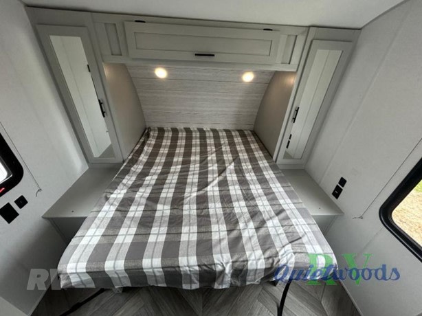 Inside an RV rental: a modern bedroom with a comfortable plaid bed, ample storage, and reading lights.. Forest River Salem FSX Toy Hauler 2019