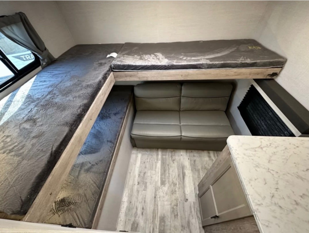 RV rental: A compact and functional interior featuring three bunk beds, a sofa, and a counter. Great for road trips.. Gulf Stream Trailmaster 2023