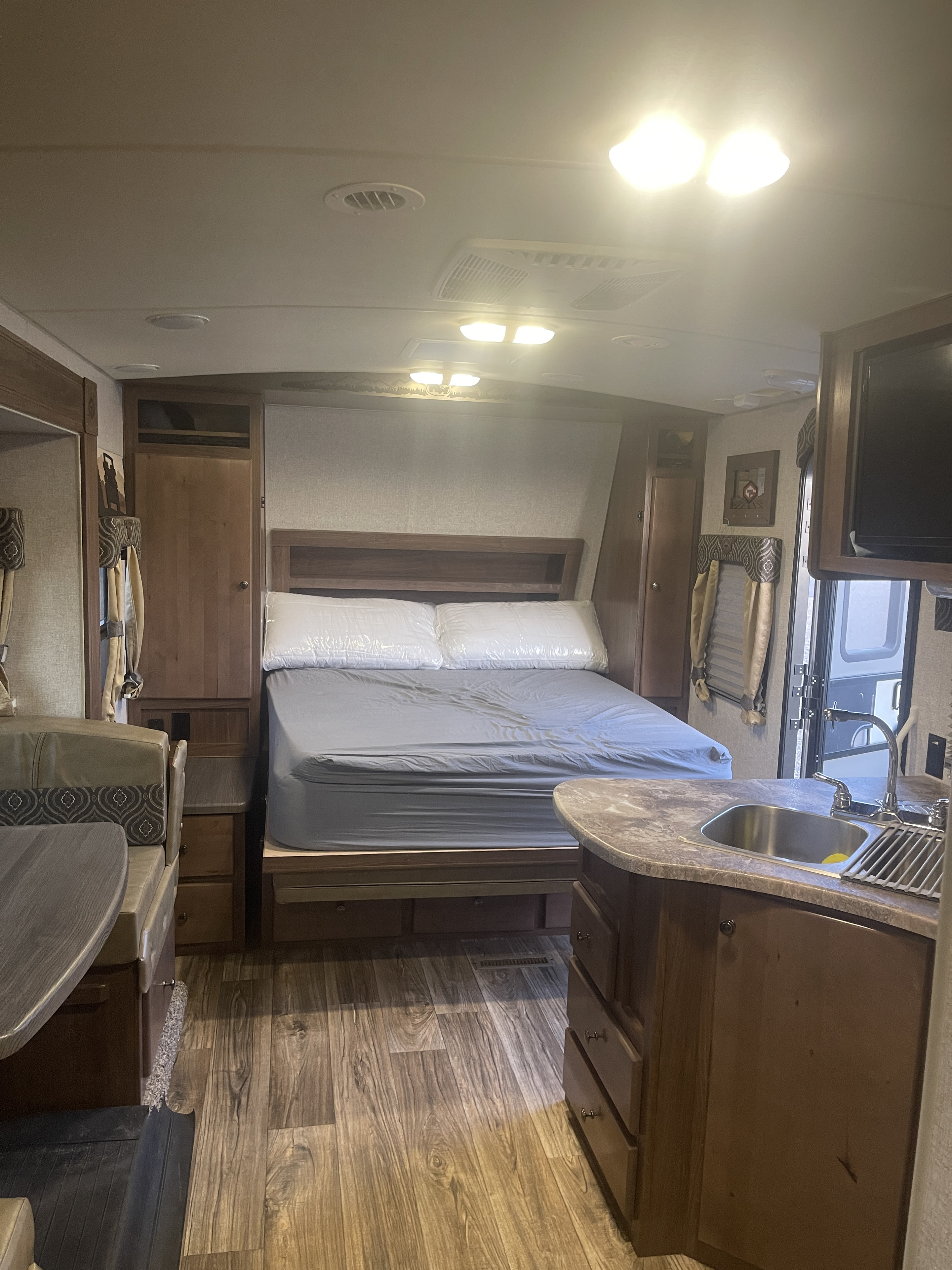 Spacious rv rental interior, featuring a bed, dinette, and kitchen. Perfect for your next adventure in a modern camper.. Nash Nash Trailer 2022