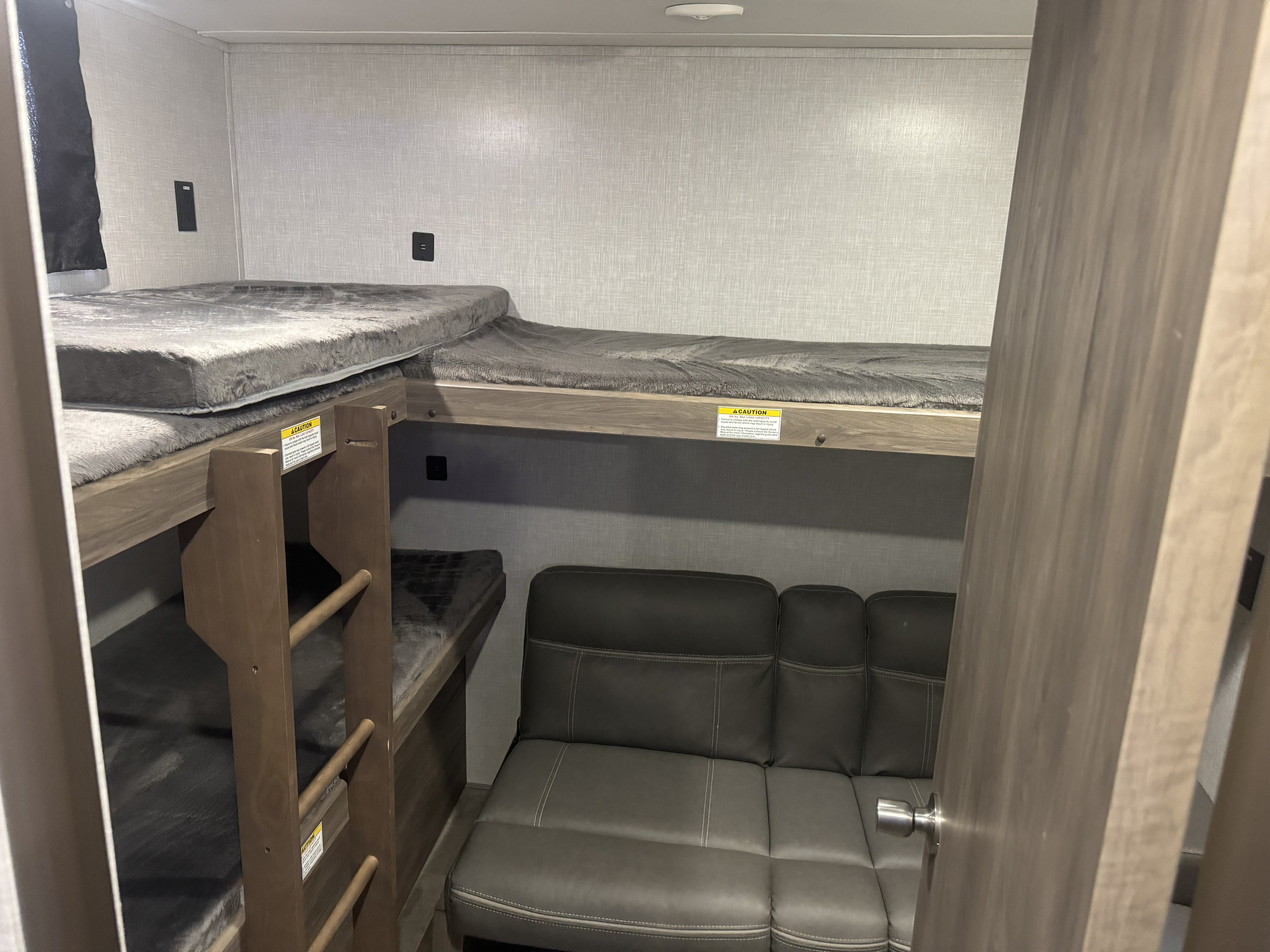 RV rental interior featuring cozy bunk beds with ladder and a comfortable couch. Ideal sleeping and living space.. Keystone Zinger 290KB 2022