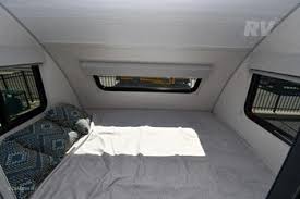 RV rental bedroom interior shows a cozy bed, side windows, and overhead window, perfect for camping trips.. R-Pod R-Pod Trailer 2024