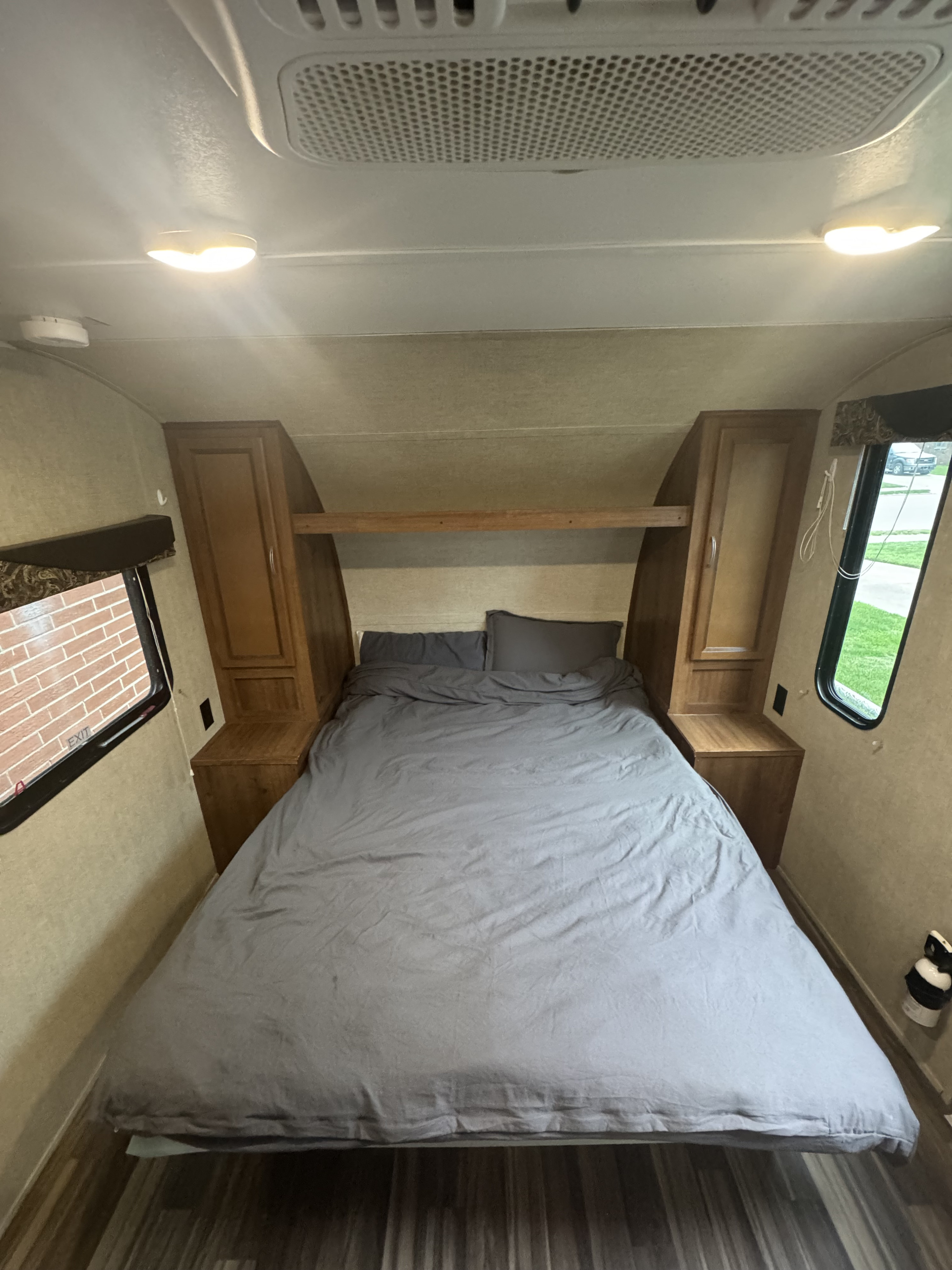 Cozy RV rental bedroom with a comfy bed, built-in storage, and bright windows. Ideal for travel.. Gulf Stream Ameri-Lite Super Lite 2017