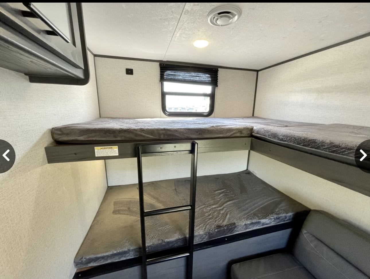 Cozy RV rental featuring L-shaped top bunks, a lower bunk, ladder, & grey mattresses. Ideal for families.. Aspen Trail Other 2021