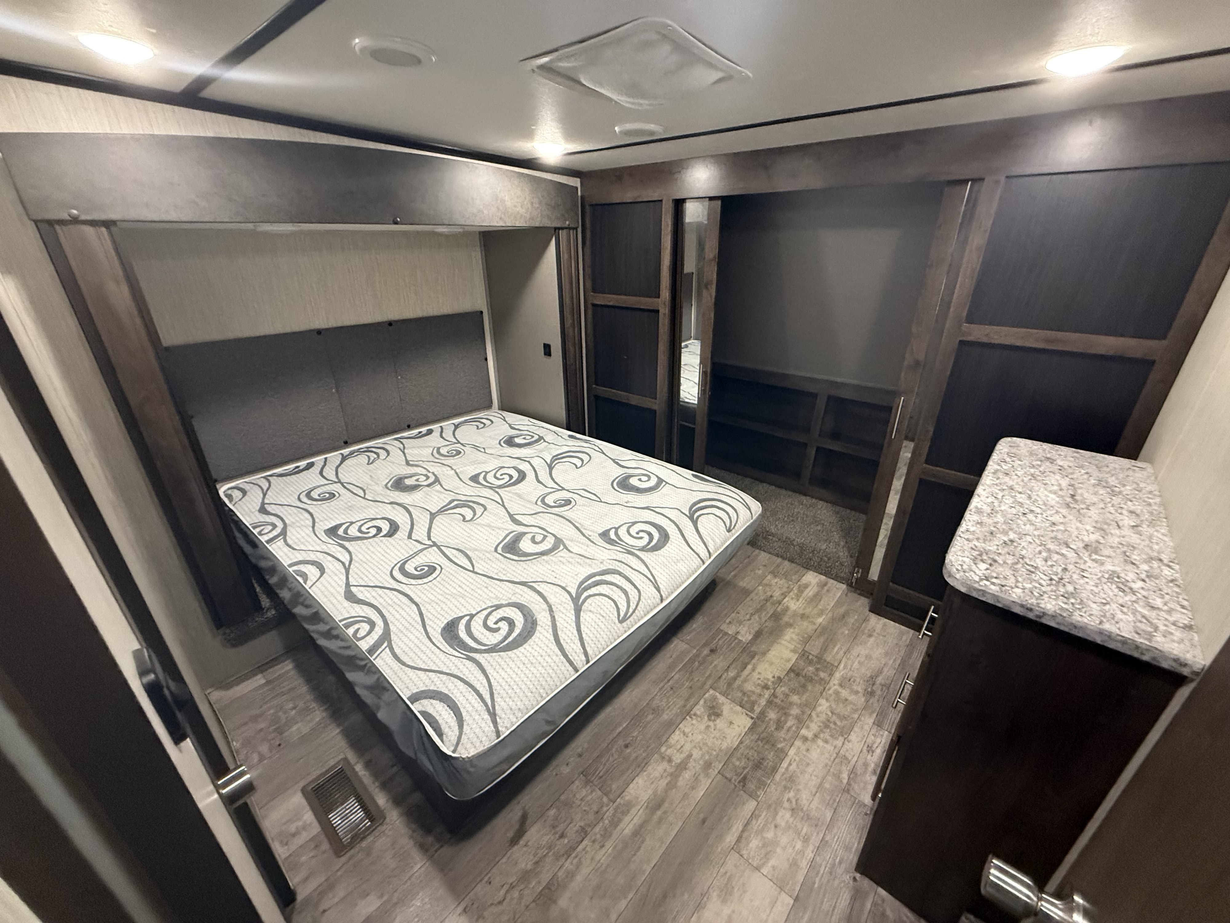 Cozy RV rental bedroom with queen bed, built-in storage, and modern finishes for comfortable travel.. Crossroads RV Volante 2020