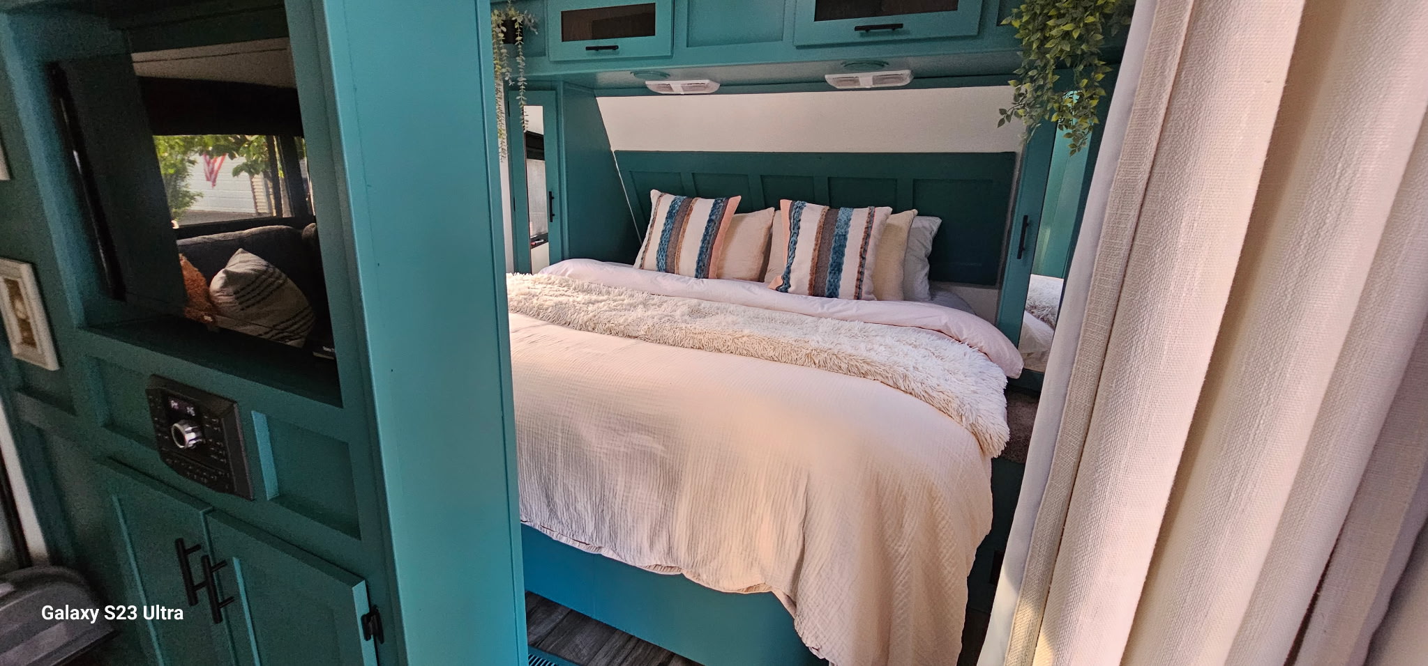 Step inside this RV rental's cozy bedroom, featuring a teal and beige palette with plush bedding.. Dutchmen Aerolite 2014