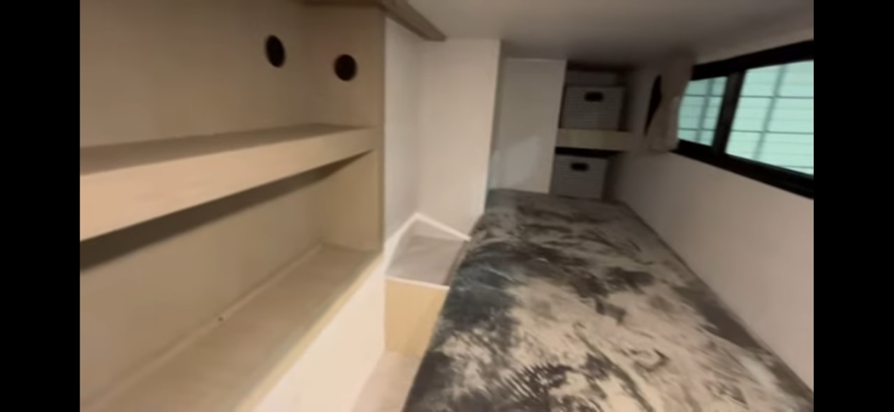 RV rental: compact interior showing a single bed, built-in shelves, storage bins, and a window.. Forest River Salem View 2024