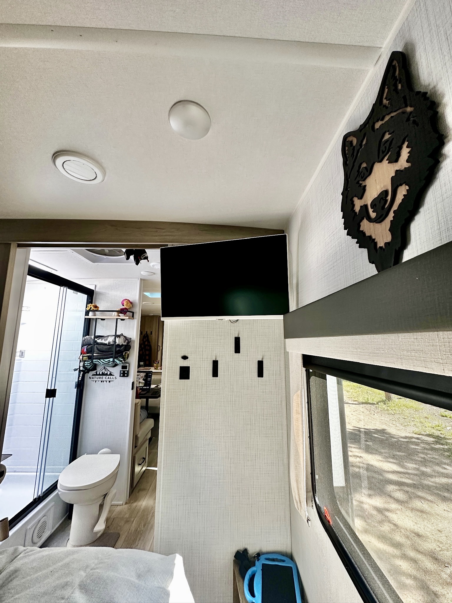 RV rental interior features a cozy bed, wall-mounted TV, and full bathroom with shower and toilet, ideal for travel.. Forest River Flagstaff Super Light 29DBH 2025
