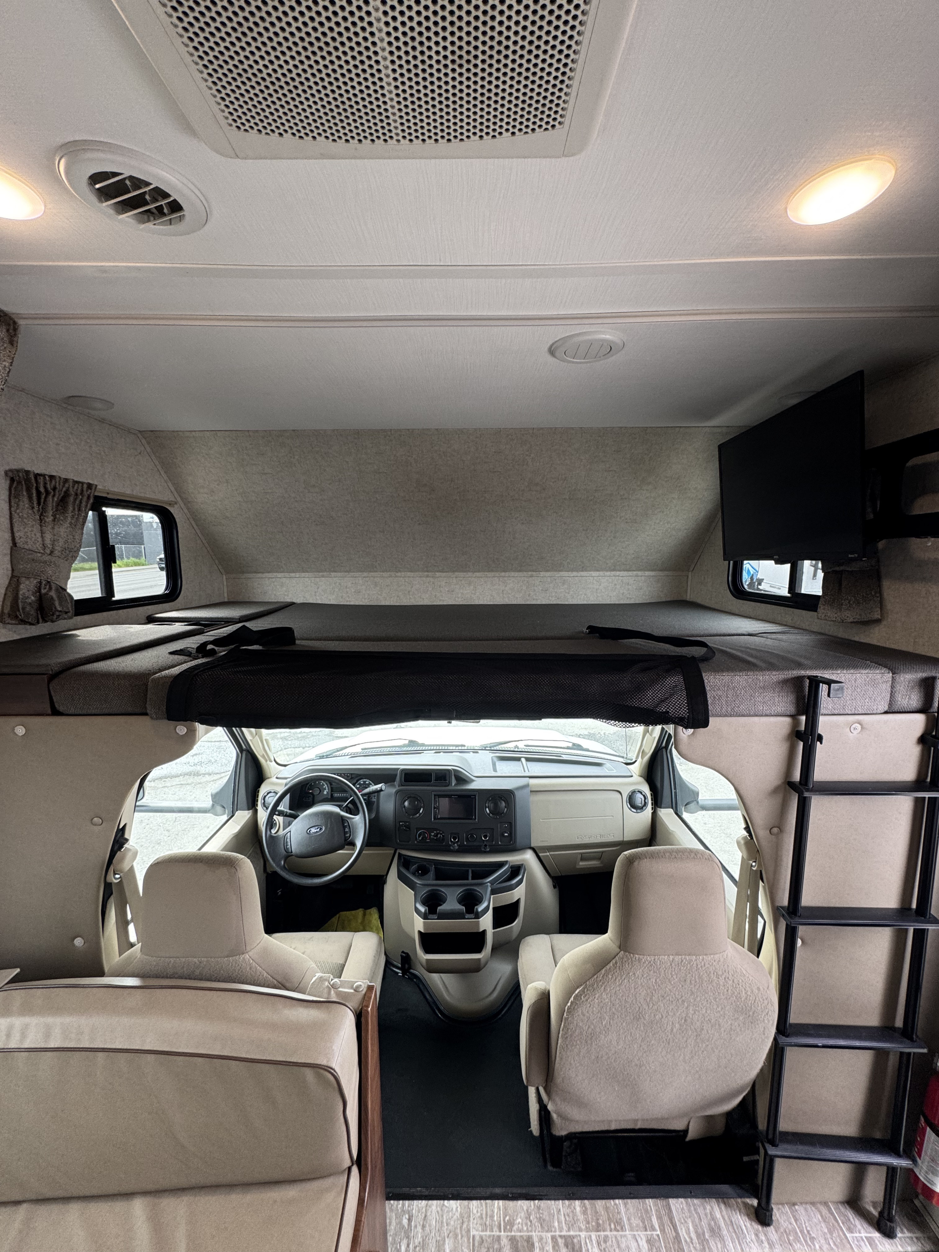RV rental: View inside a motorhome with a large cab-over bed, safety net, ladder, and a clear view of the driver's area.. Forest River Sunseeker LE 2020