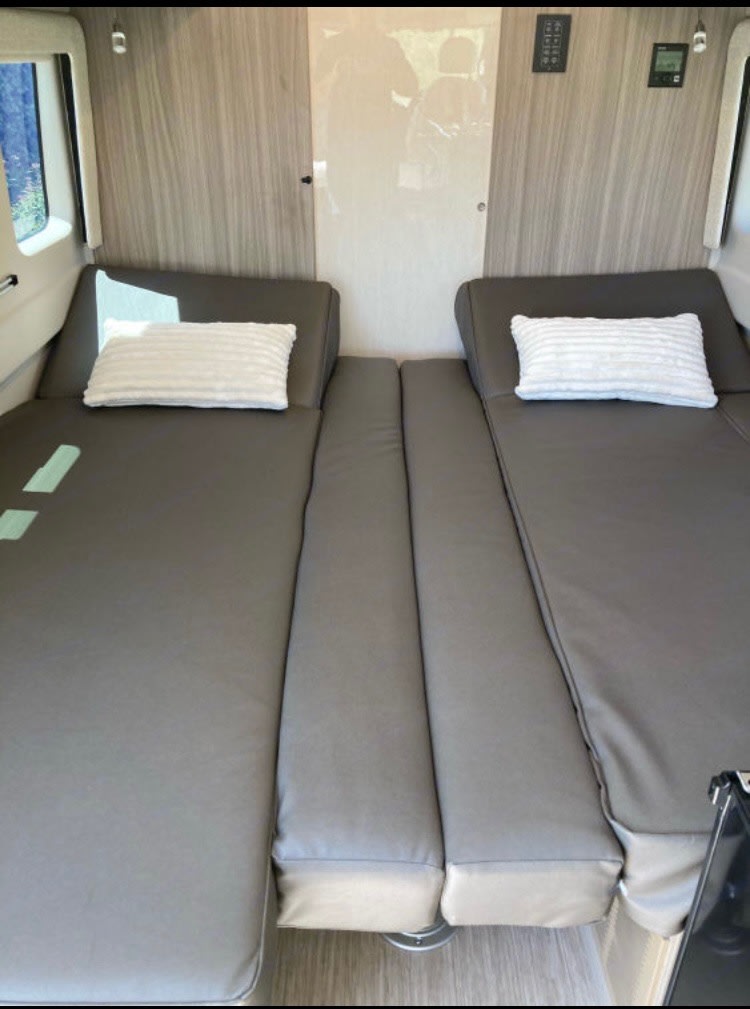RV rental: two side-by-side gray cushion beds with pillows. Convertible for versatile sleeping or seating.. Jayco Swift 2021