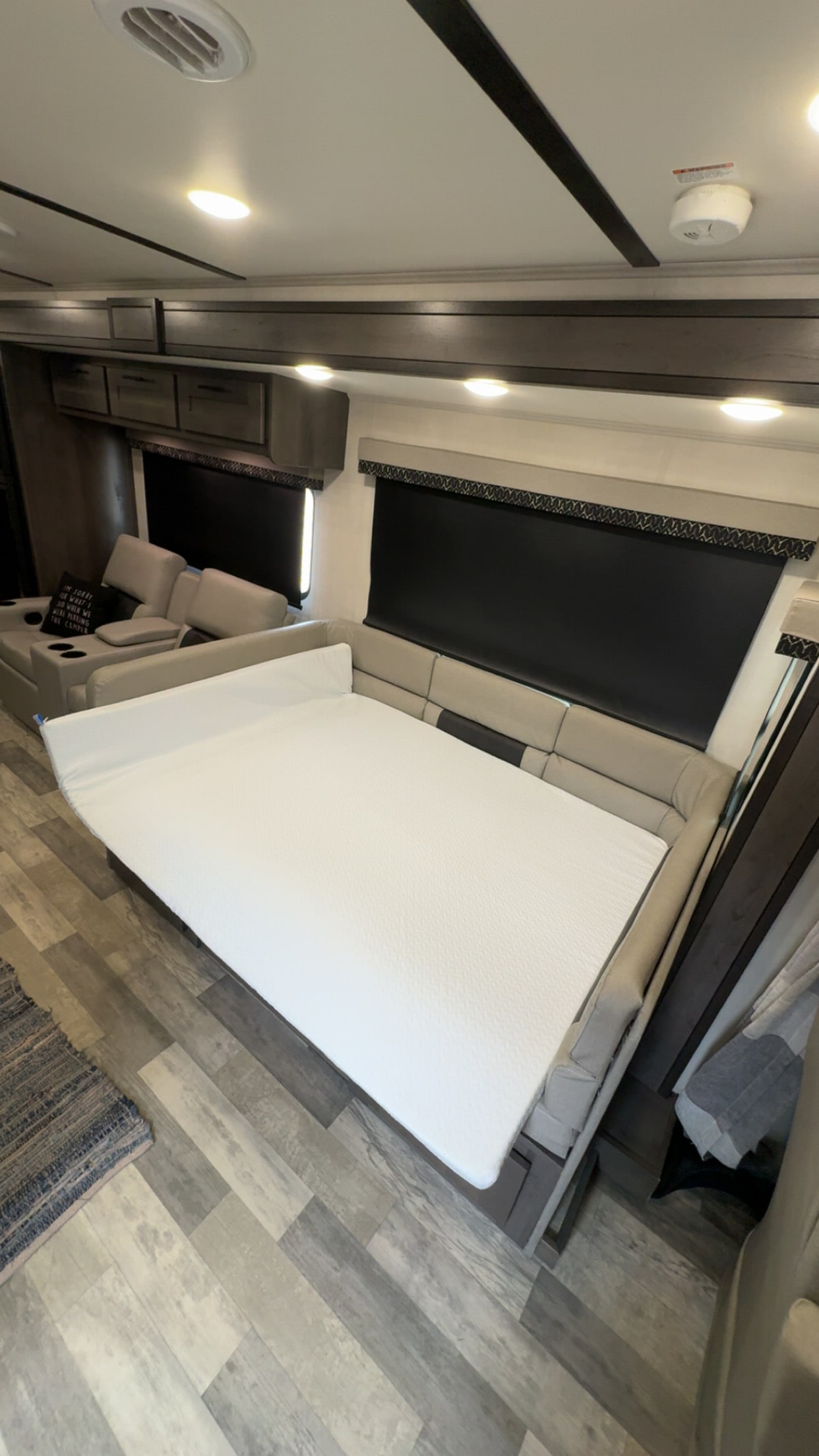 Modern RV rental interior with a convertible bed, cozy sofa, and wood-look flooring.. FR3 FR3 Motorhome 2022