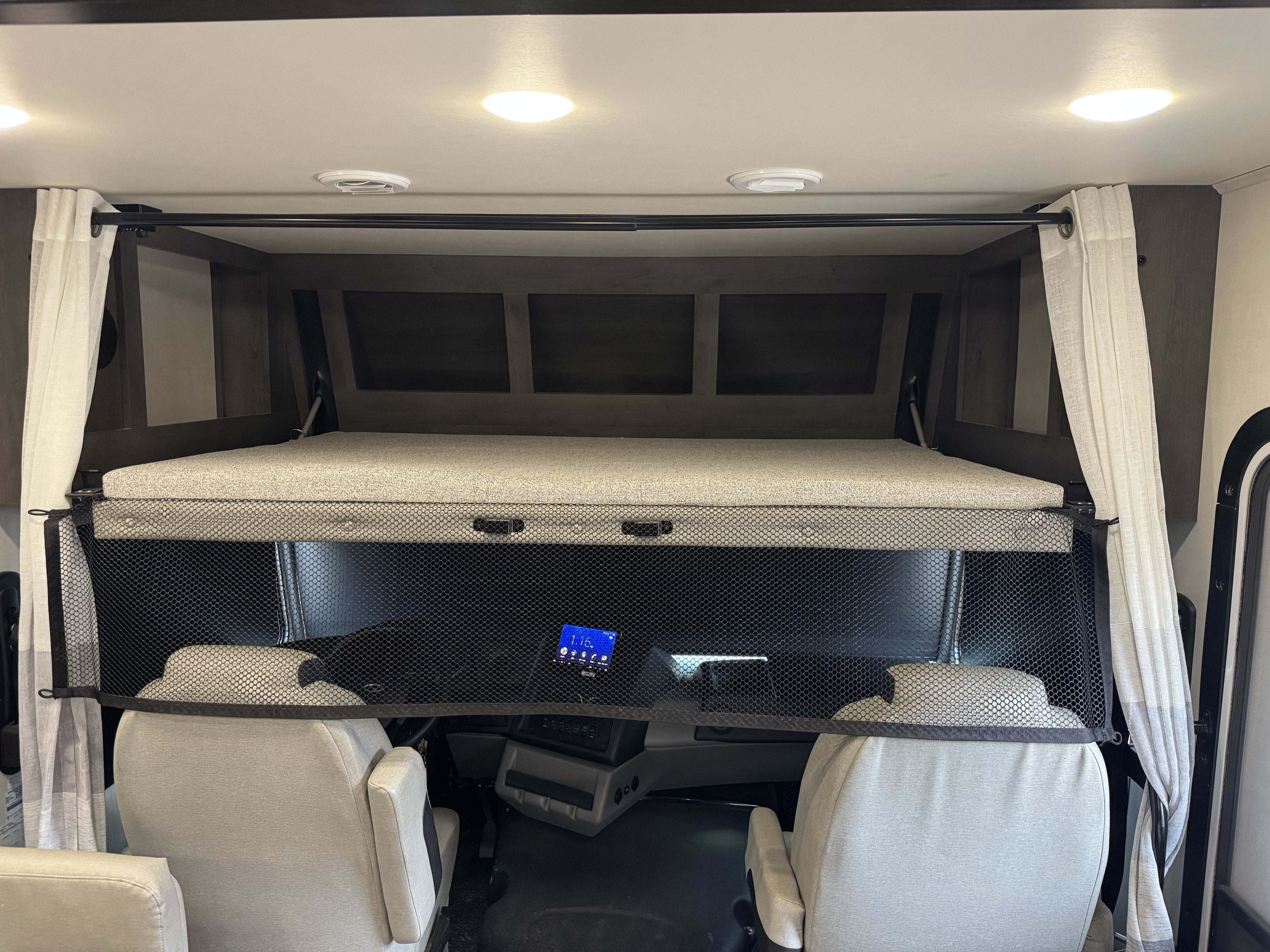 Inside an RV rental: An overhead bunk bed with a safety net rests above the driver's cab and front seats, offering extra sleeping.. FR3 FR3 Motorhome 2022