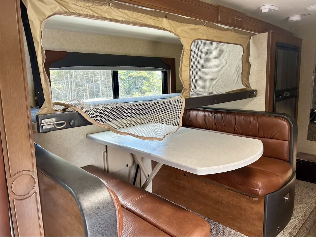 RV rental interior: A cozy dinette with a fold-down bunk bed above, ready for adventure.. Lance 1172 2017