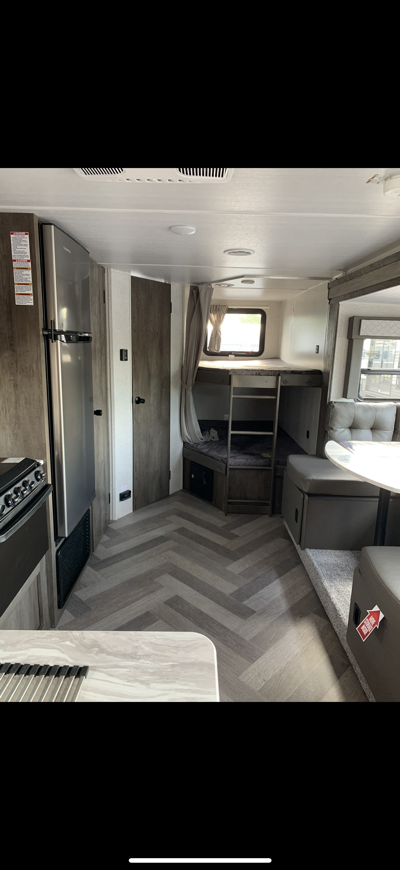 Spacious rv rental interior featuring a modern kitchen area, large fridge, bunk beds, and dinette.. Forest River Salem Cruise Lite 2021