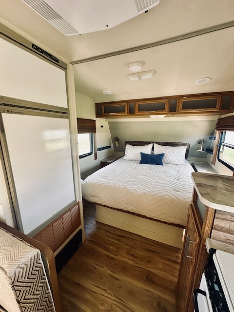 RV rental interior: A bright and spacious view of a comfortable bedroom, wood floors, and partial kitchen area.. Terry L Series 1995
