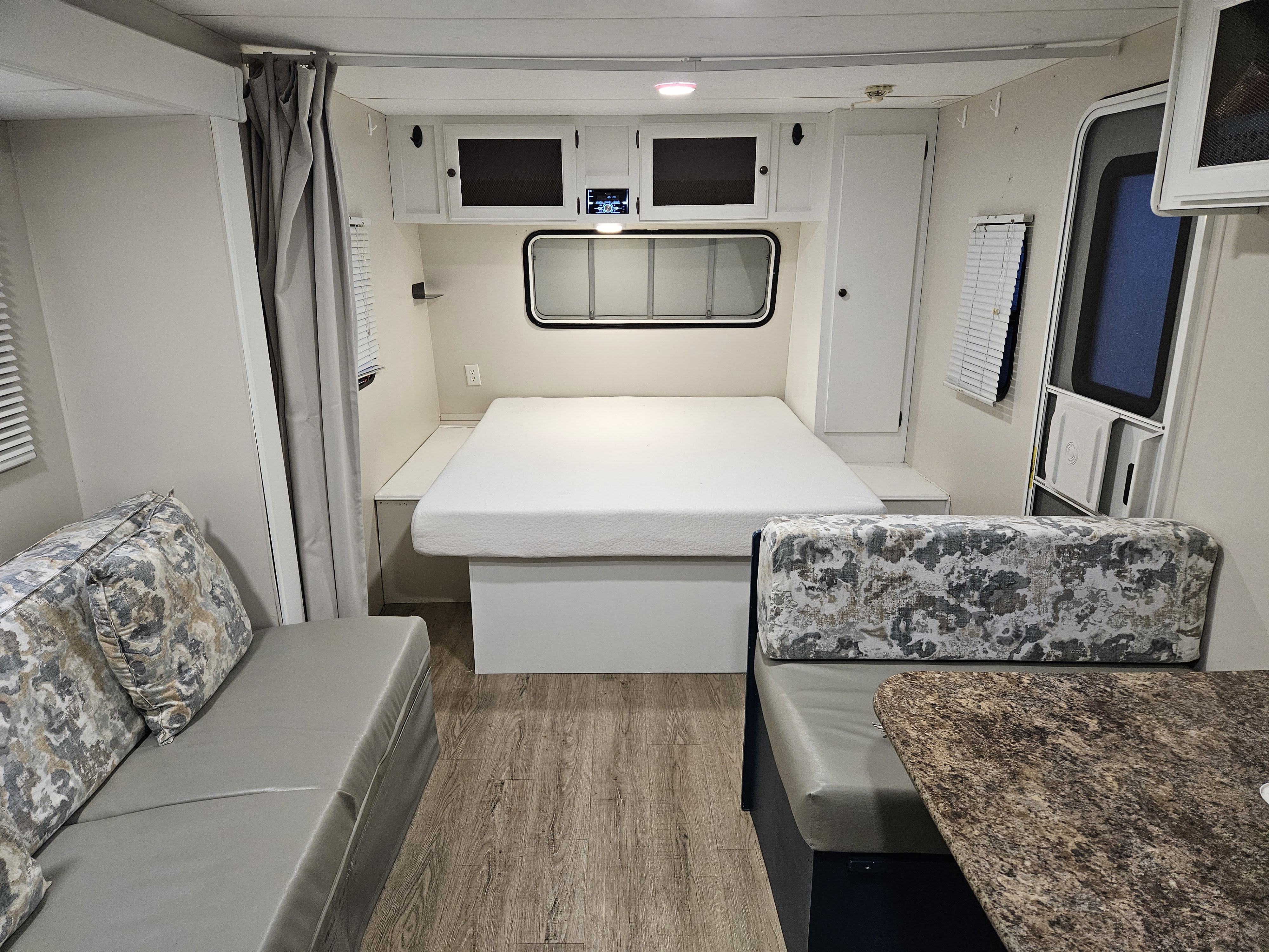 Spacious RV rental interior featuring a comfortable bed, dinette with table, and plush sofa seating.. Spree Escape 2014