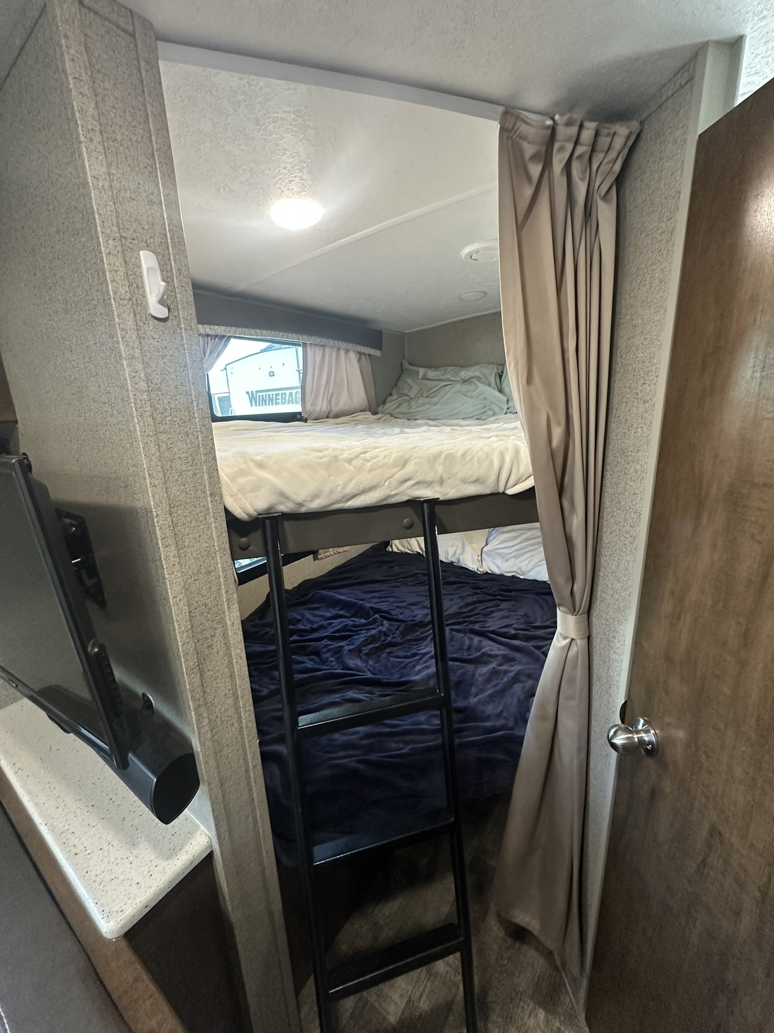 Cozy rv rental bunk beds with privacy curtain & ladder. Ideal for family trips in this Winnebago RV.. Forest River Rockwood Mini Lite 2020