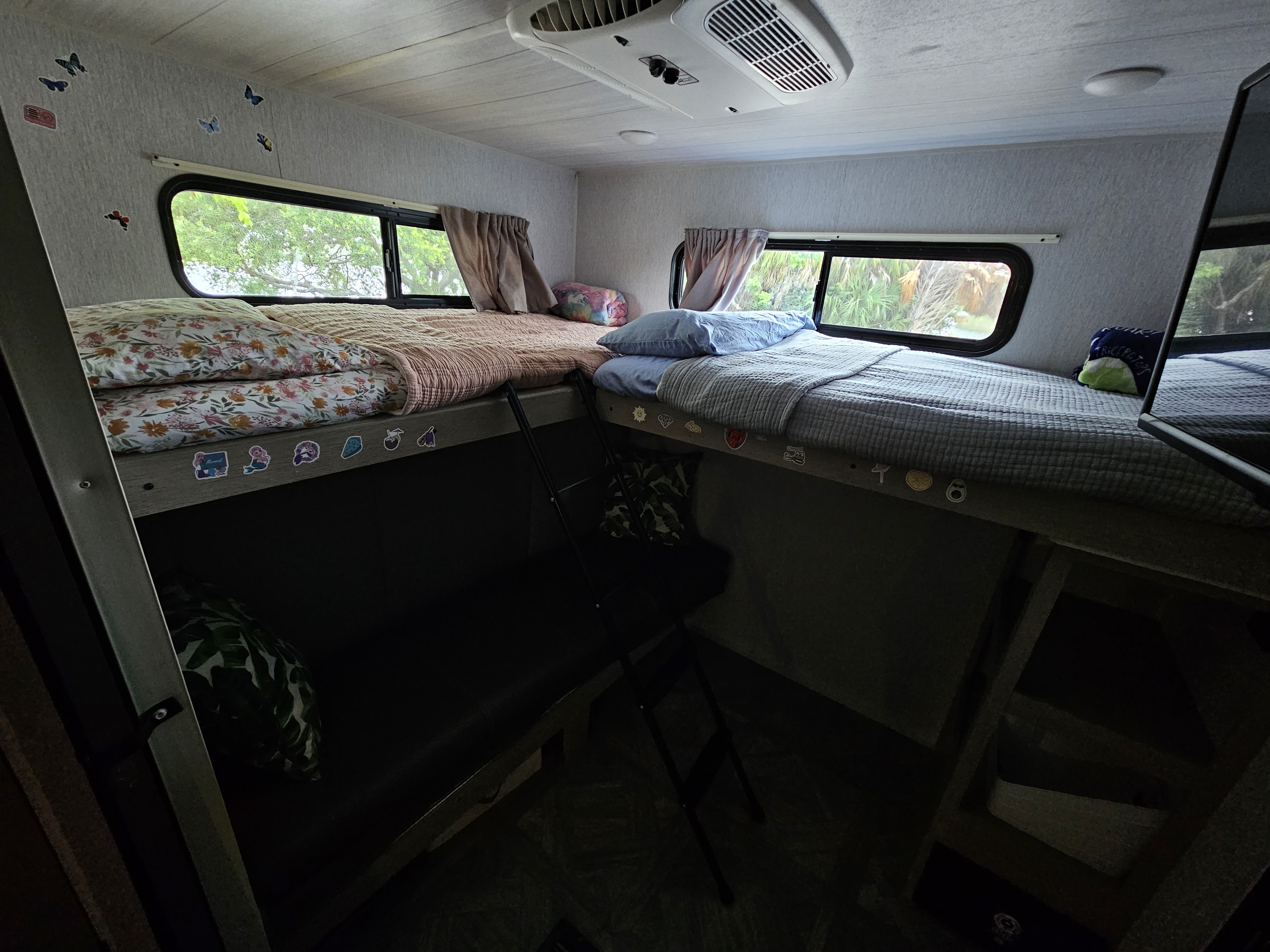 Inside a cozy RV rental: four bunk beds with various bedding, bright windows, and a ceiling AC unit.. Forest River Salem Platinum Model 29VBUD 2023