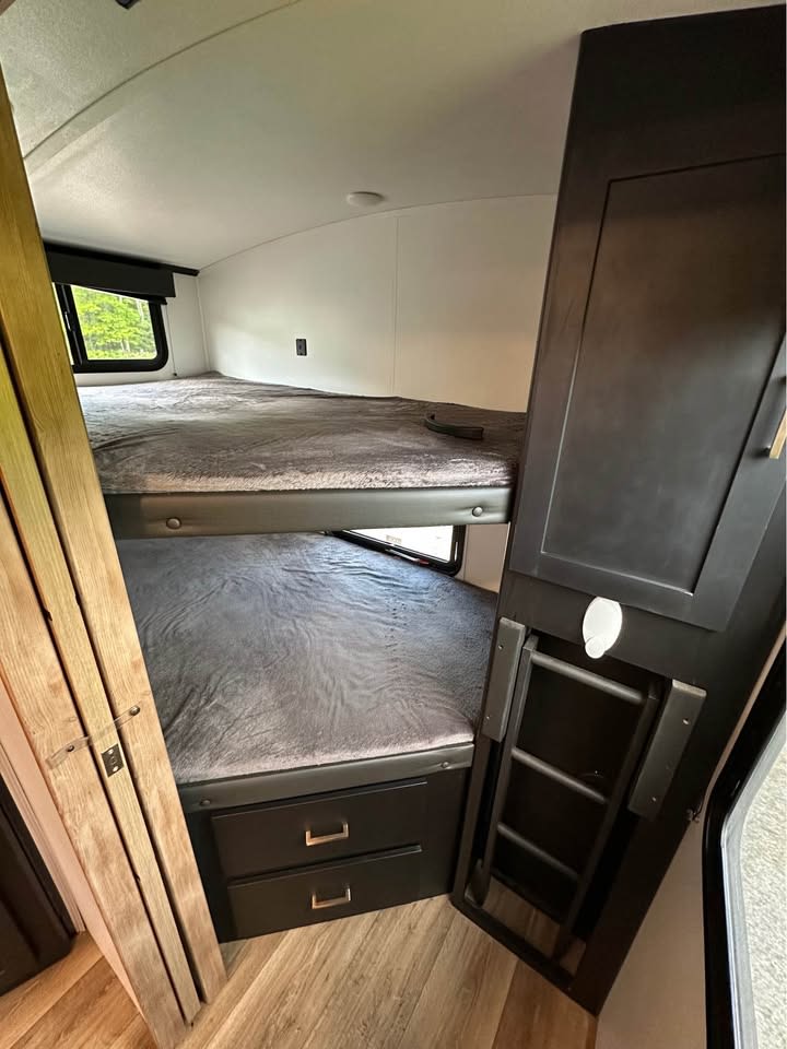 Cozy RV rental bunk beds with storage & ladder, perfect for family adventures!. Keystone RV Outback Ultra-Lite 2022