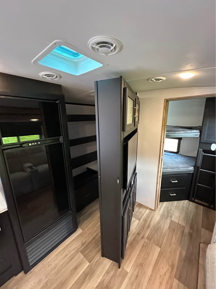 Inside your RV rental: a modern interior with a large refrigerator, entertainment center, and a separate bunk room.. Keystone RV Outback Ultra-Lite 2022