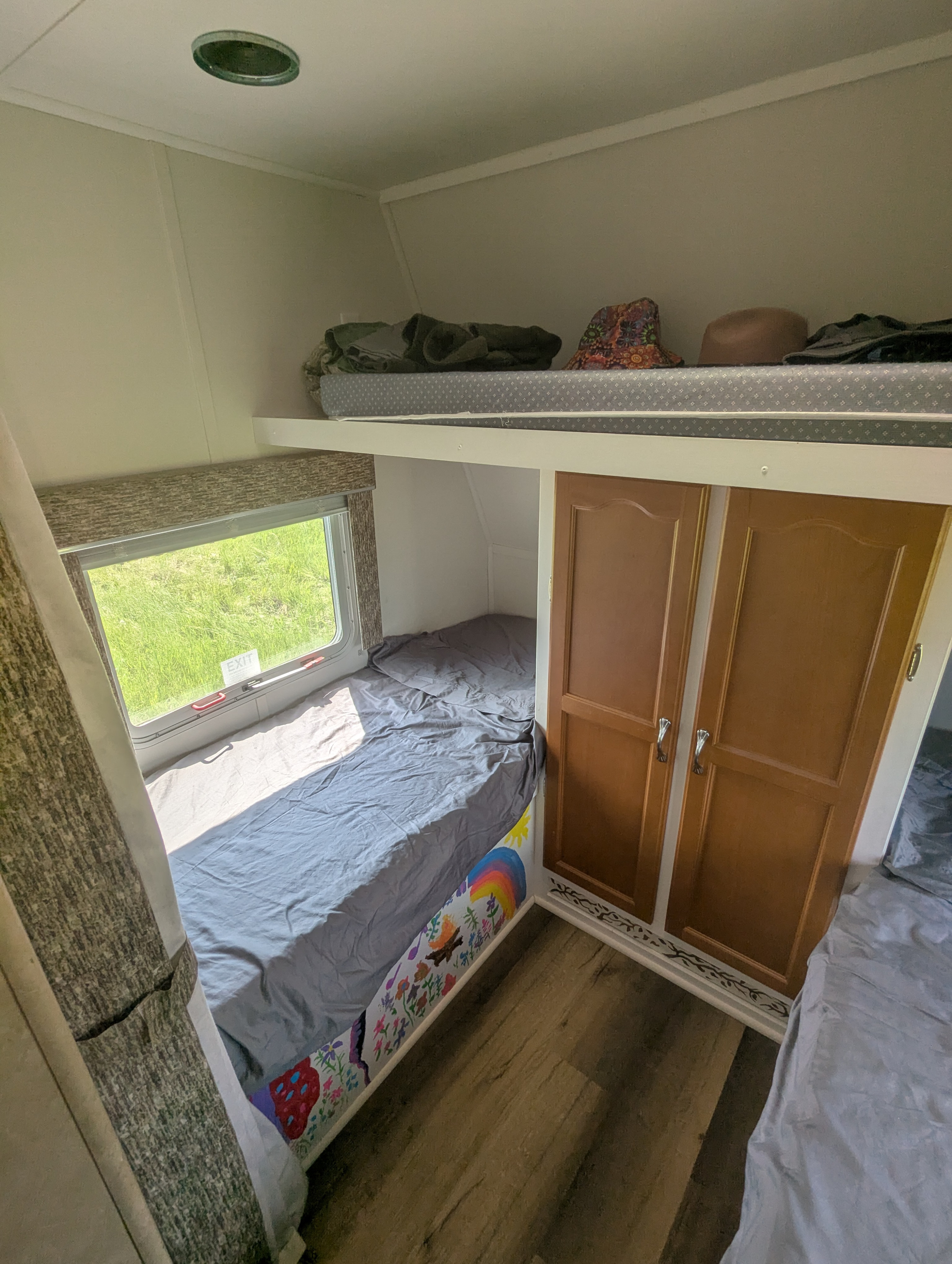 Cozy RV rental: two bunk beds, lower with window, upper for extra sleep/storage. Features colorful wall art.. Gulf Stream Ameri-Lite 2006