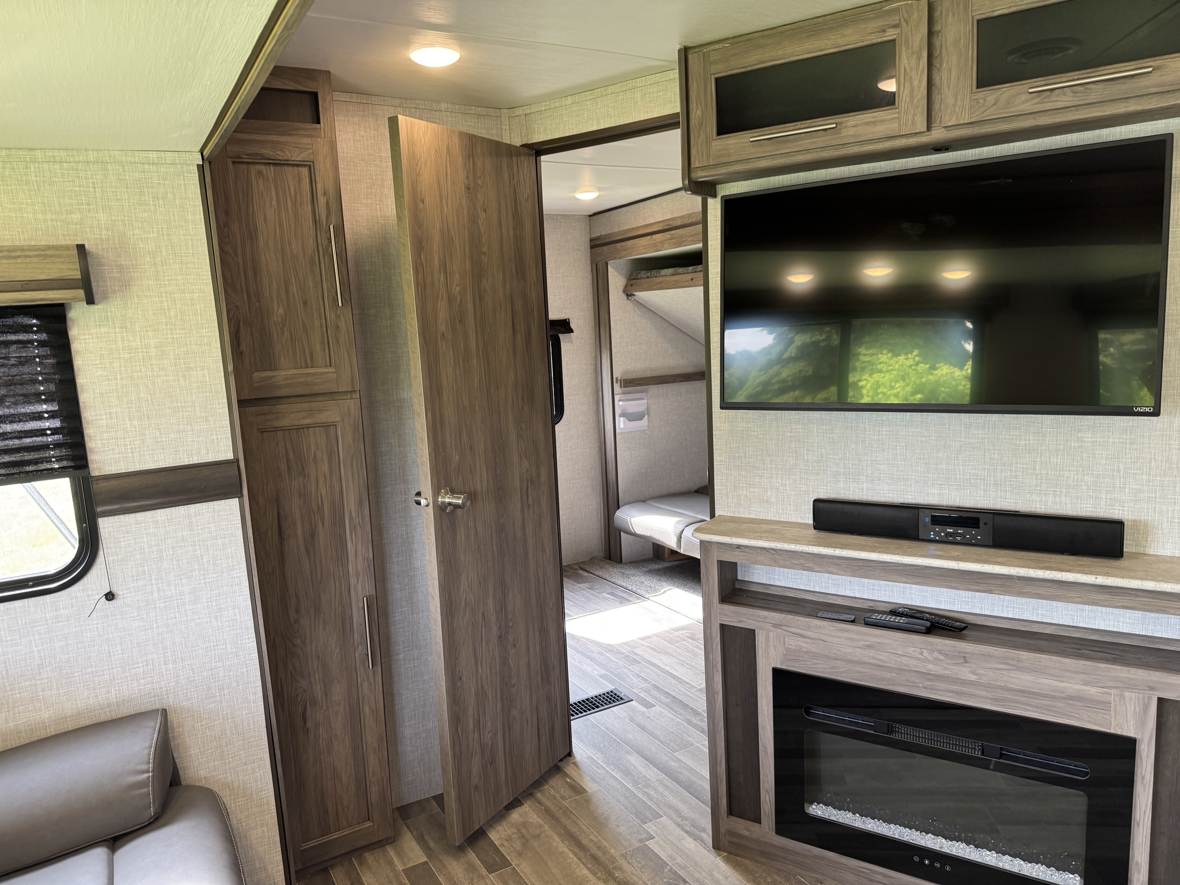 Inside an RV rental: a comfortable living space with TV, fireplace, and bunks. Modern design.. Crossroads Zinger 2022