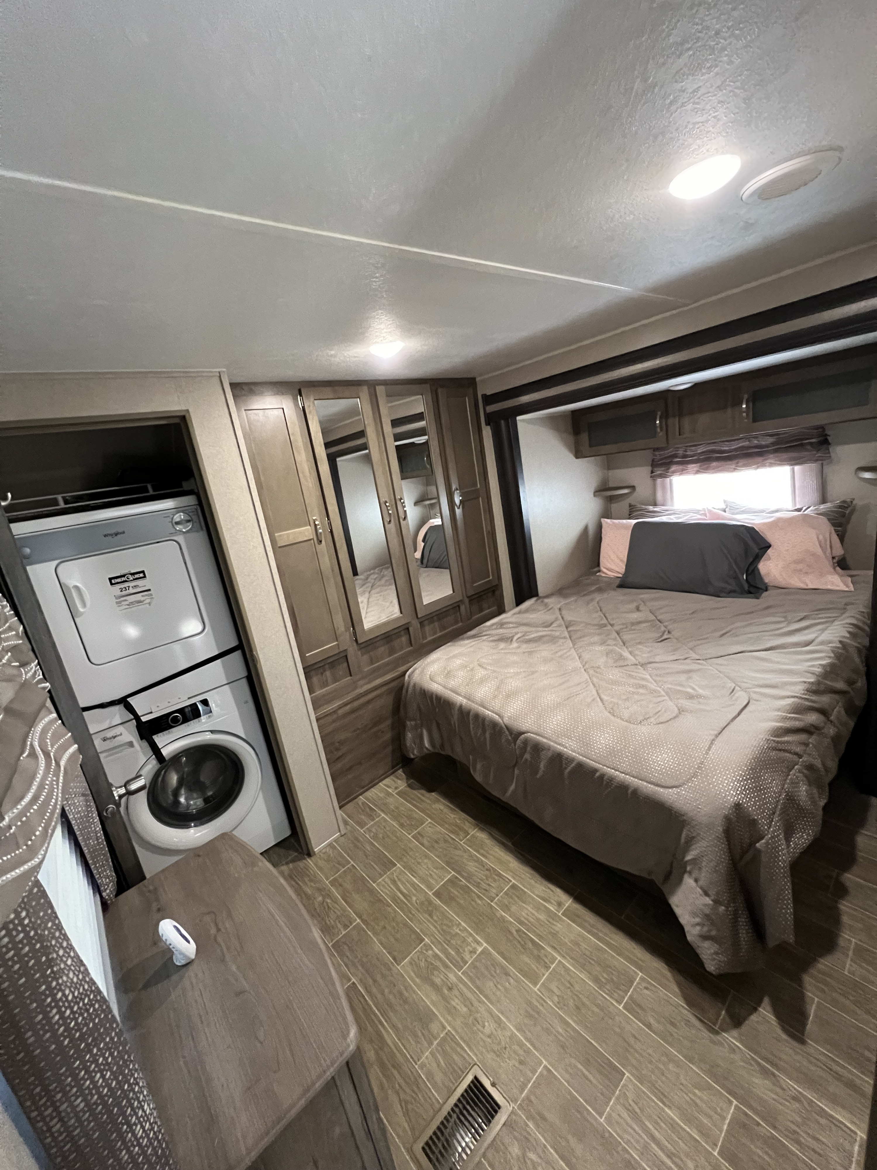 RV rental bedroom: Features a bed, mirrored wardrobe, and stackable washer/dryer for ultimate convenience on the go.. Forest River Palomino Puma 2020