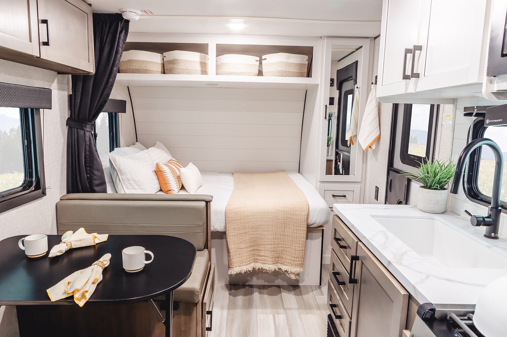 Spacious RV rental interior featuring a bright kitchen, comfortable bed, and dinette area with scenic window views.. Wayfinder RV Go Play 19BH 2025