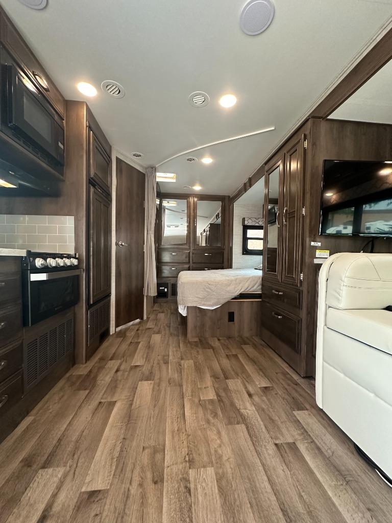 Spacious RV rental interior with kitchen, living area, and bedroom. Perfect for your next adventure!. Jayco Redhawk 2021