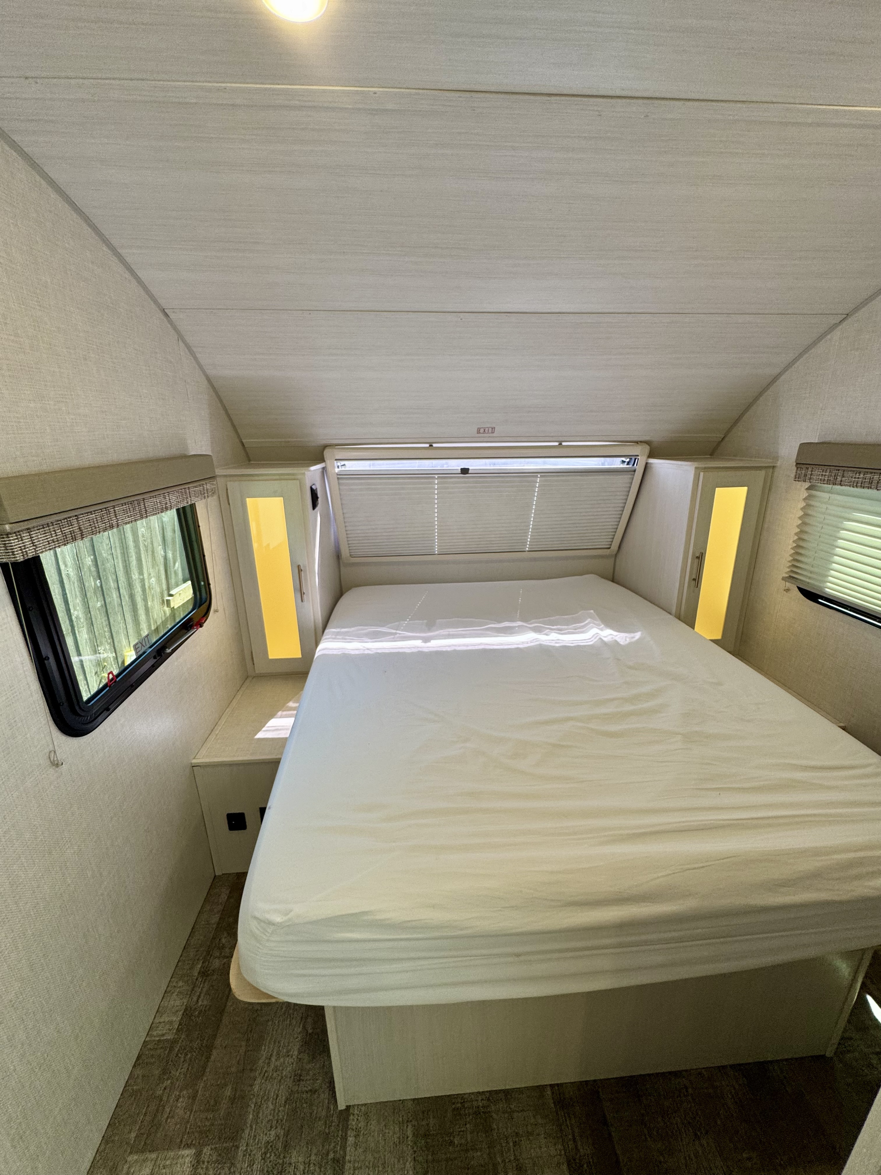 Step into this bright RV rental bedroom, featuring a comfy white bed, side windows, and ample storage for a cozy stay.. Forest River R-Pod RP-202 2022