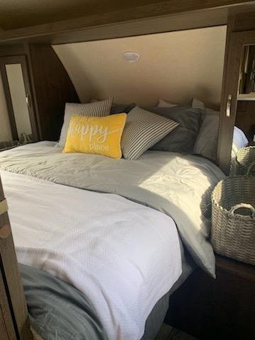 Cozy RV rental bedroom: A comfortable bed with yellow "happy place" pillow, ideal for your next trip.. Forest River Salem Cruise Lite 2018