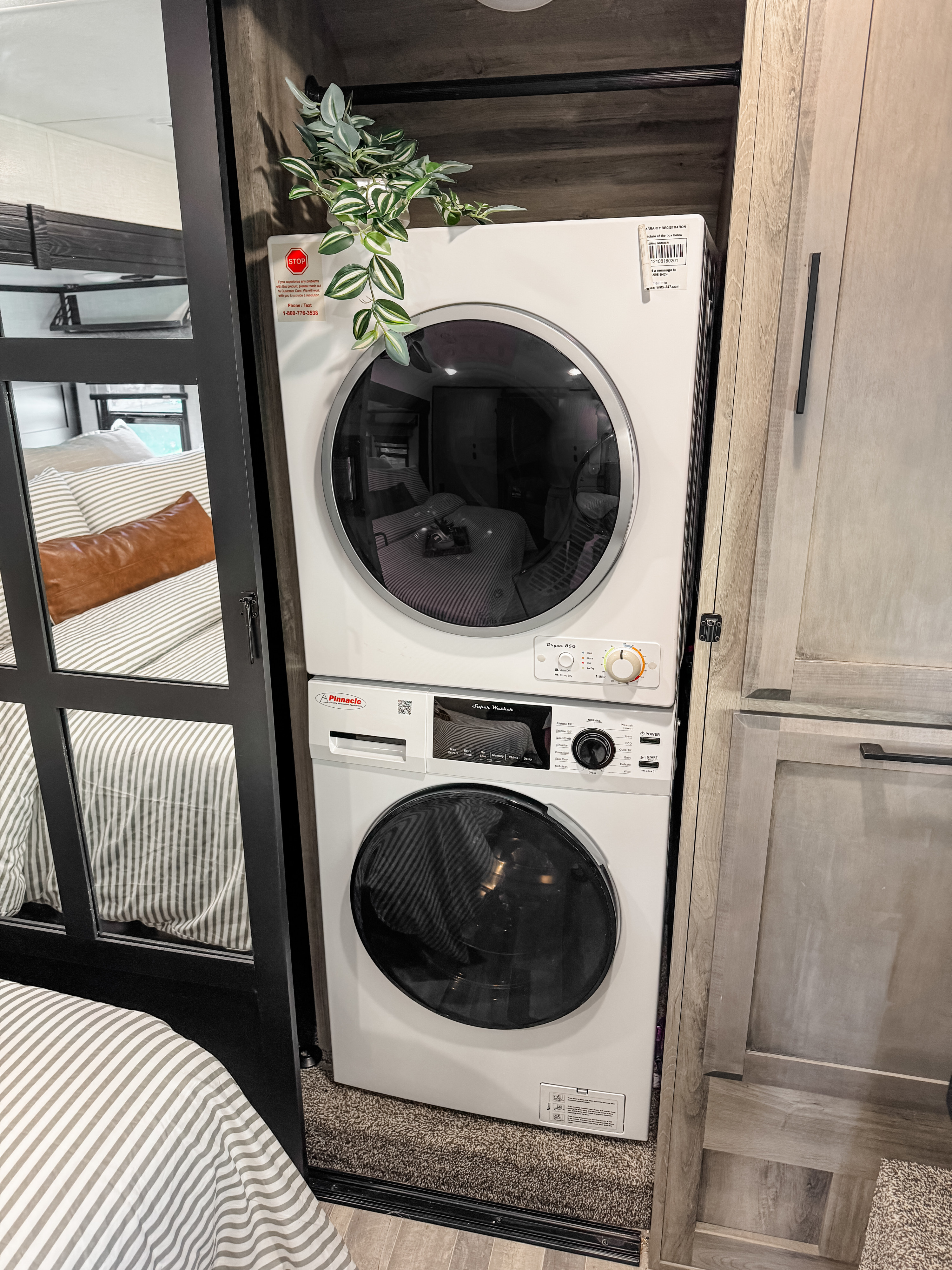 An RV rental's stacked washer and dryer setup offers laundry convenience, with a glimpse of the bedroom.. Durango Gold 2023