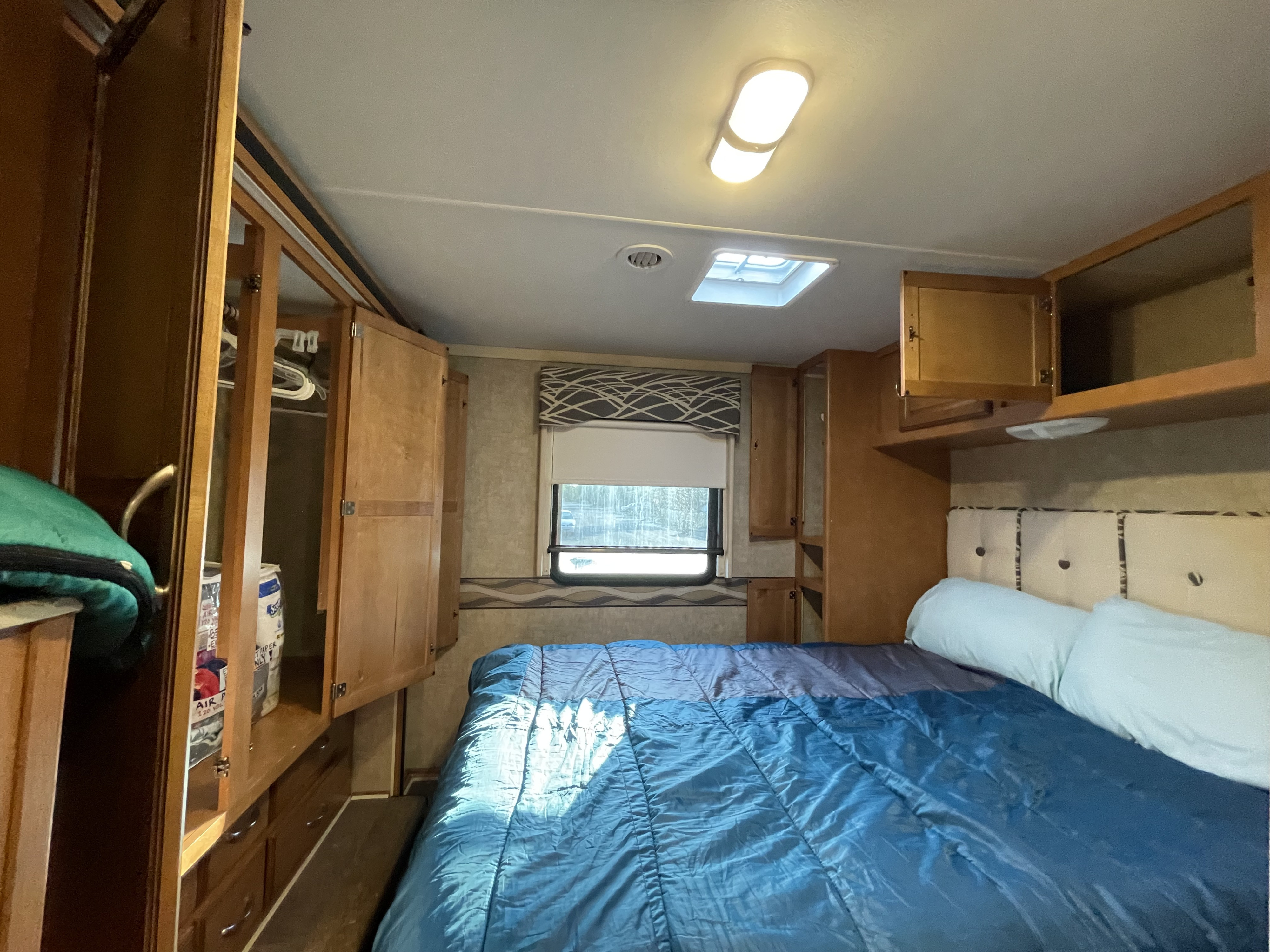 RV rental bedroom: comfortable bed, built-in storage, skylight, and window. Perfect for your next trip.. Winnebago Minnie Winnie 2017