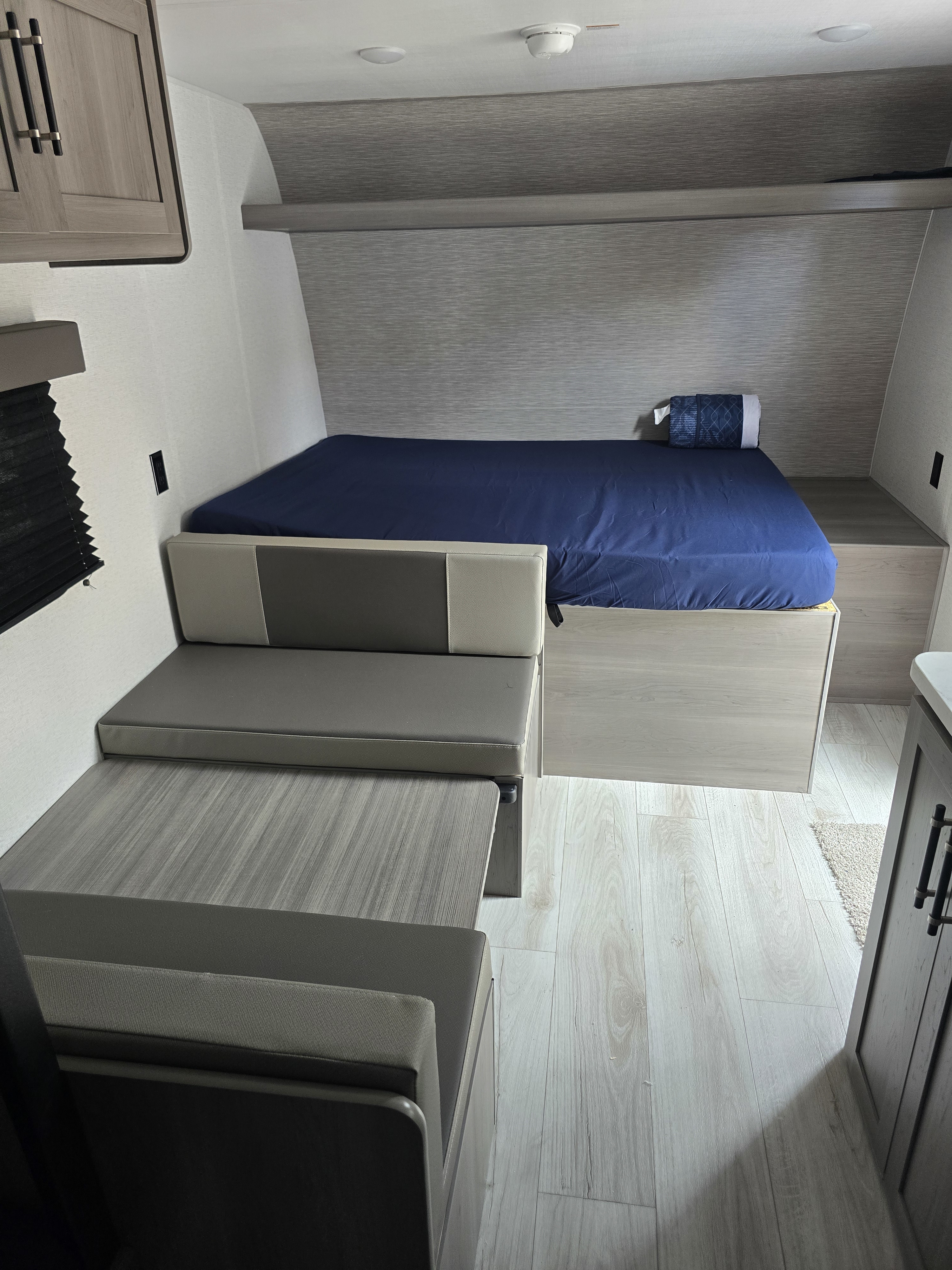 Spacious RV rental interior featuring a cozy bed and convertible dinette, ideal for travel.. Keystone Hideout Sport 2025