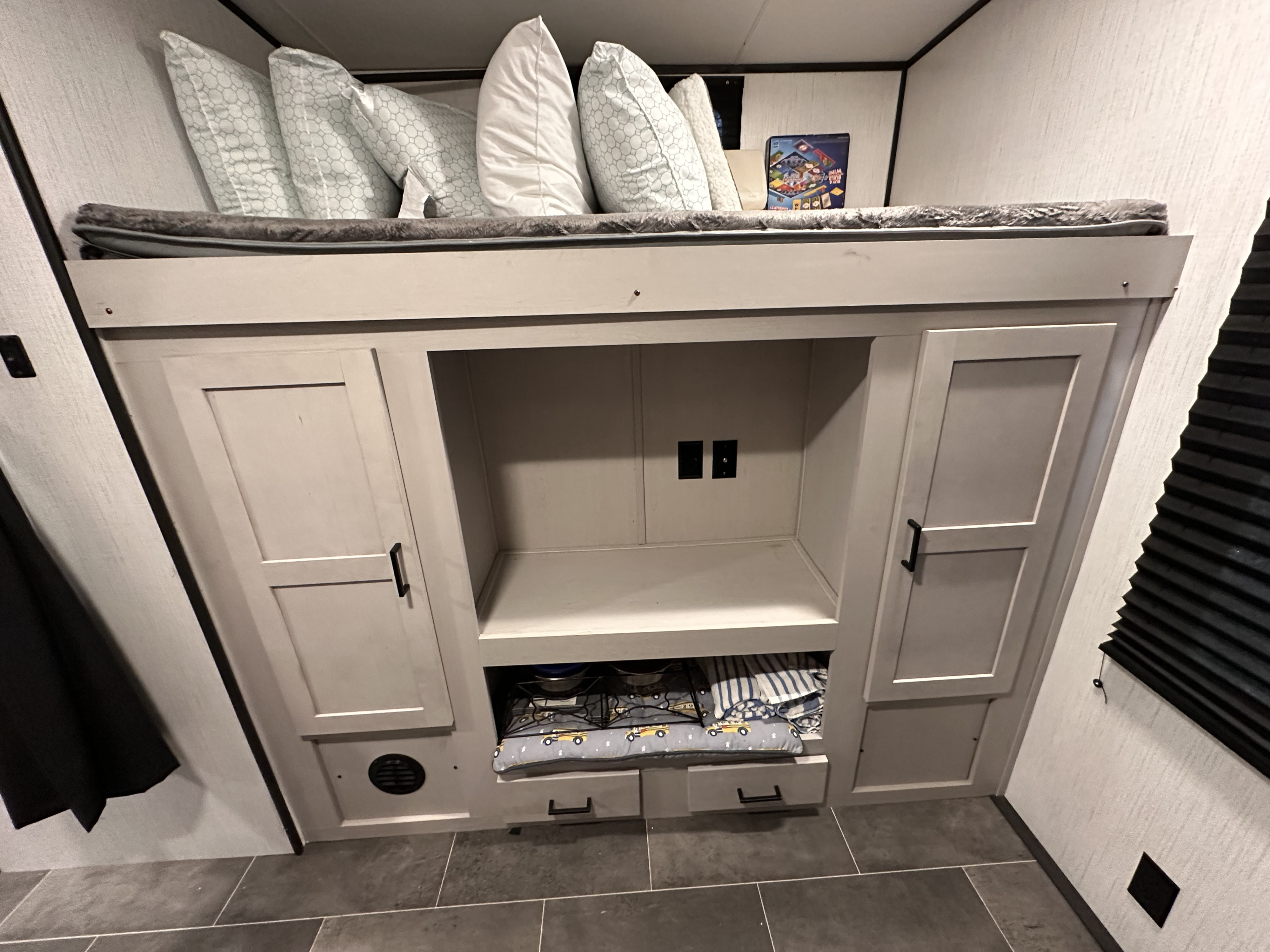 RV rental: Bunk bed with pillows over integrated storage cabinets, drawers, and a media area. Practical RV interior.. Heartland RVs Mallard 2022