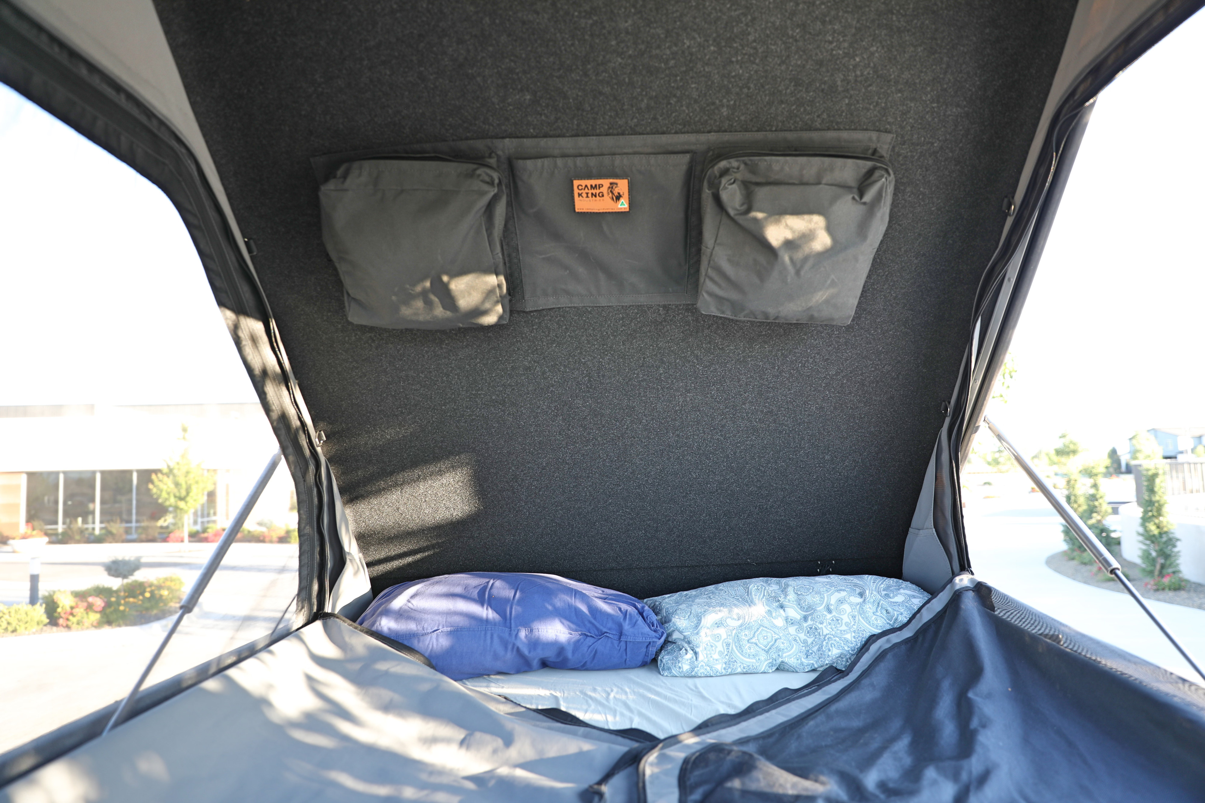 Cozy RV rental pop-top camper interior with bed, storage, and open windows offering scenic views for your outdoor adventure.. AEV Jeep Gladiator JT370 Classic 2022