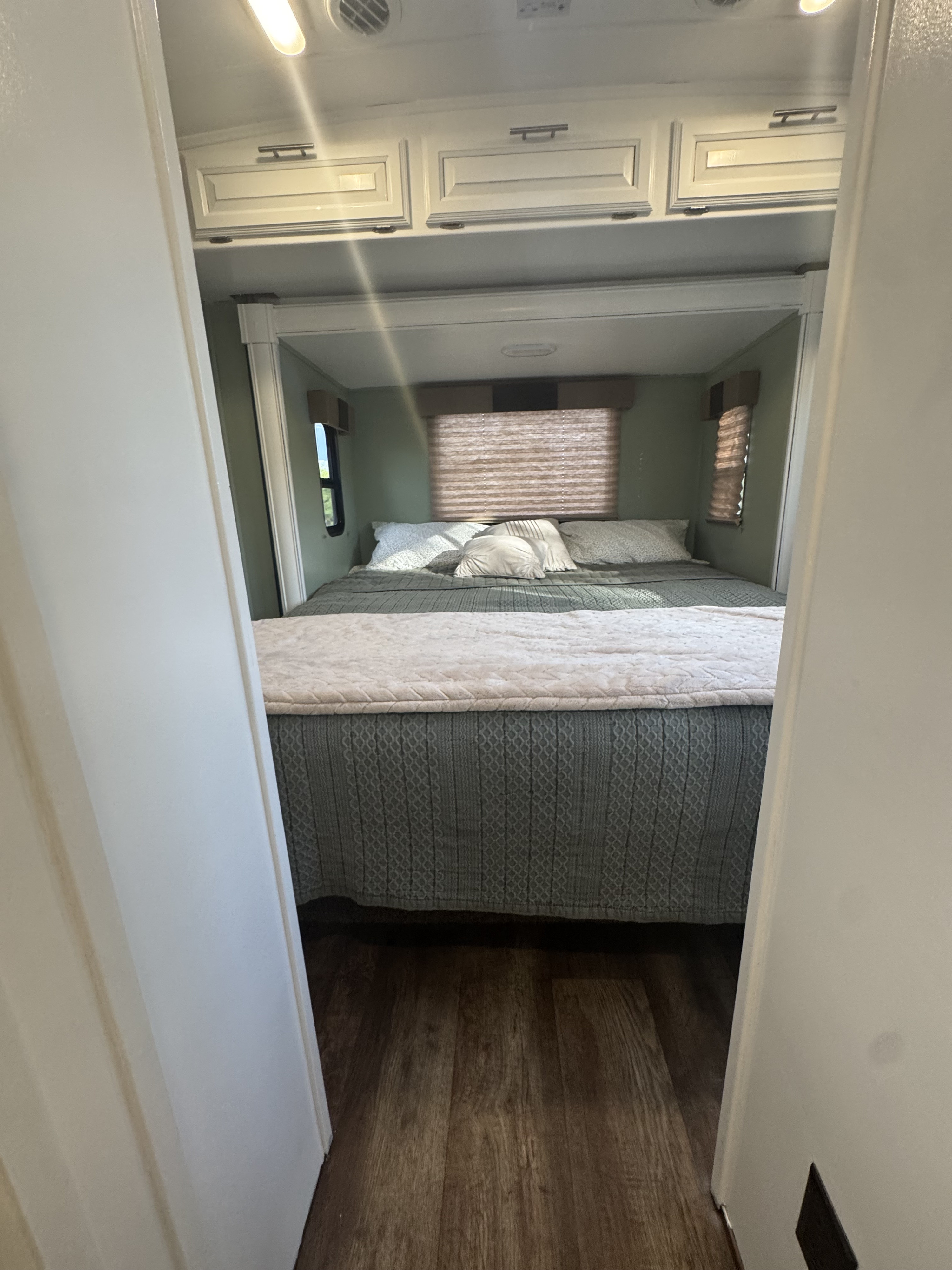 Step into this inviting RV rental bedroom featuring a comfortable bed, overhead storage, and natural light from windows.. FR3 FR3 Motorhome 2016
