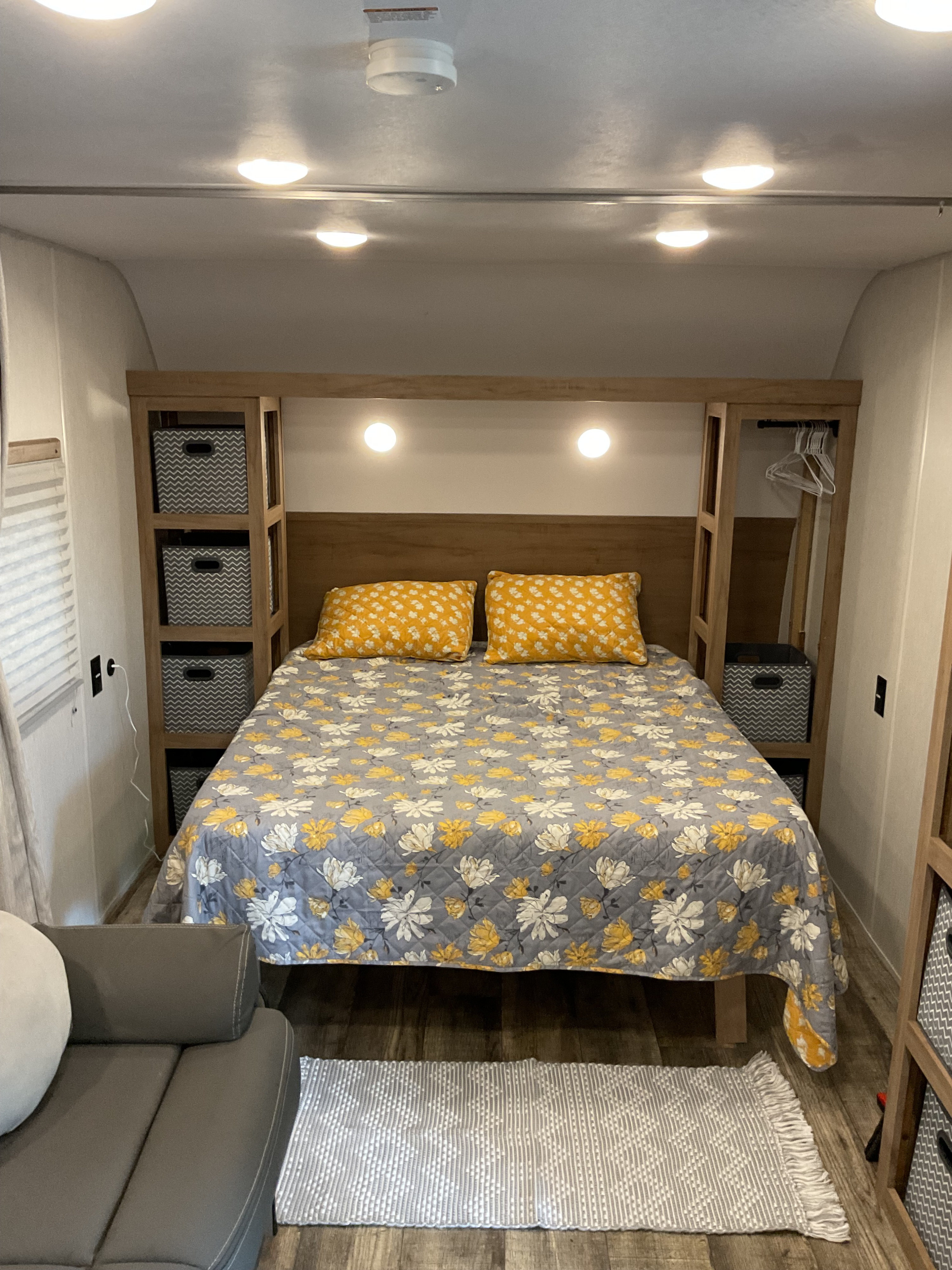 Cozy RV rental bedroom with floral comforter, built-in storage, and warm lighting for a comfortable stay.. Forest River Wolfden 26ev 2024