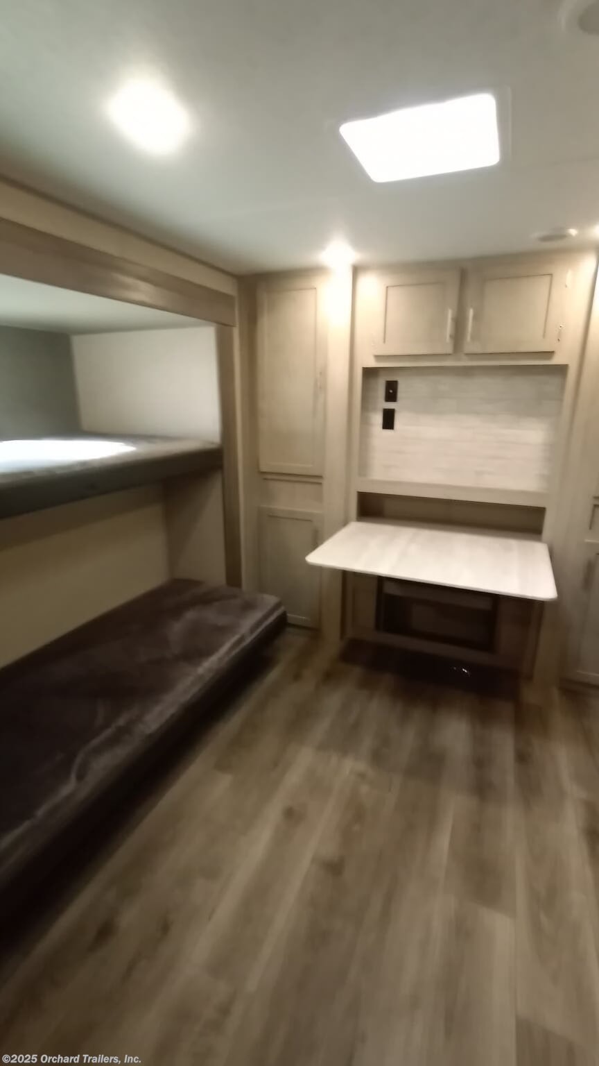 Modern RV rental bunkhouse: convertible bed, built-in desk, storage, light flooring. Ideal for family adventures.. Coachmen Catalina 2023