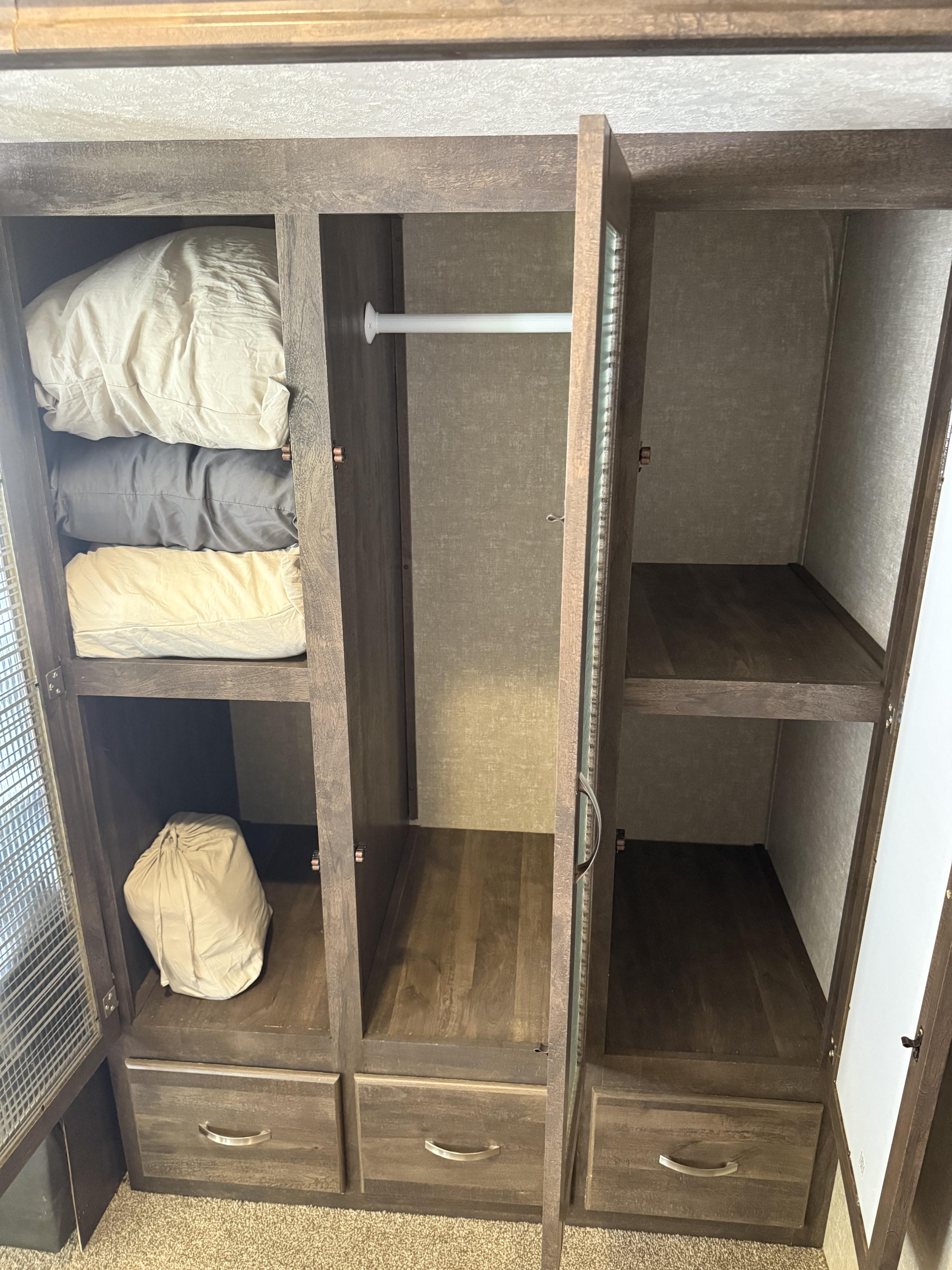 RV rental: Spacious open wardrobe featuring shelves for bedding, a clothes rod, and multiple storage drawers.. Forest River Vibe Extreme Lite 2017